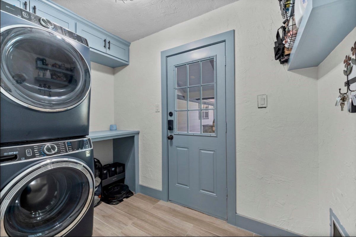 12710 Mutiny Lane, Tomball, TX 77377 Dedicated laundry room with a stacked washer and dryer, cabinetry, and a folding counter.