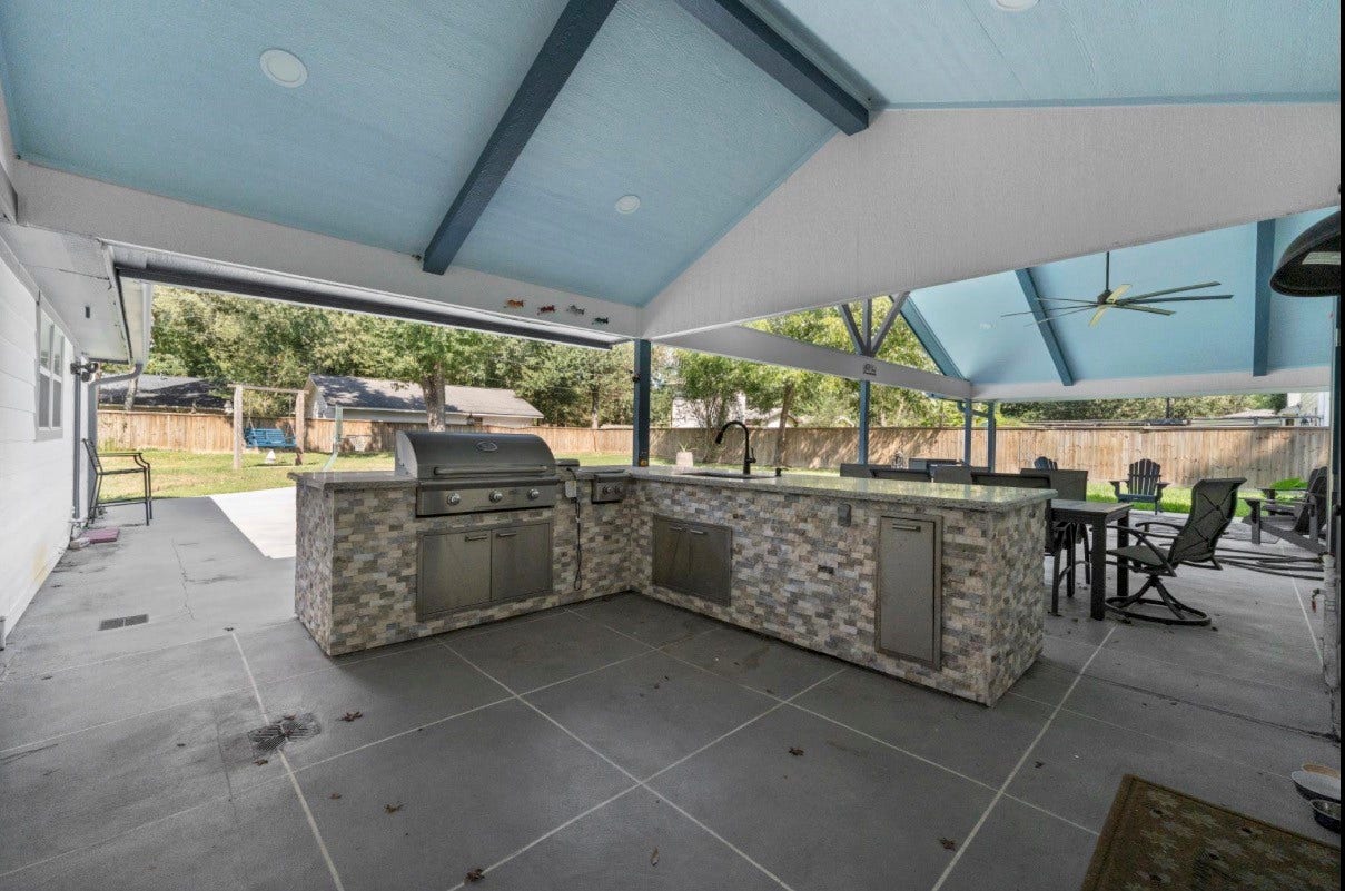 12710 Mutiny Lane, Tomball, TX 77377 Covered outdoor kitchen with a built-in grill and space for dining and gathering.
