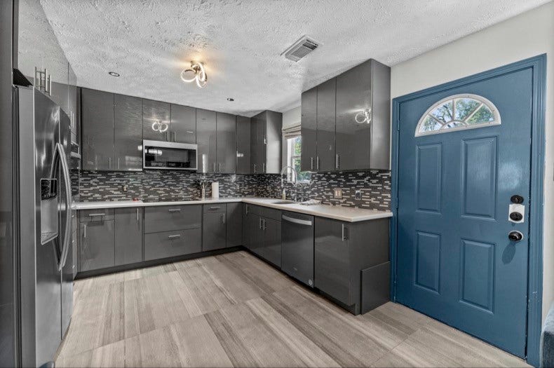 12710 Mutiny Lane, Tomball, TX 77377 Guest-suite kitchen with wraparound counters, a tile backsplash, and an exterior entry door.