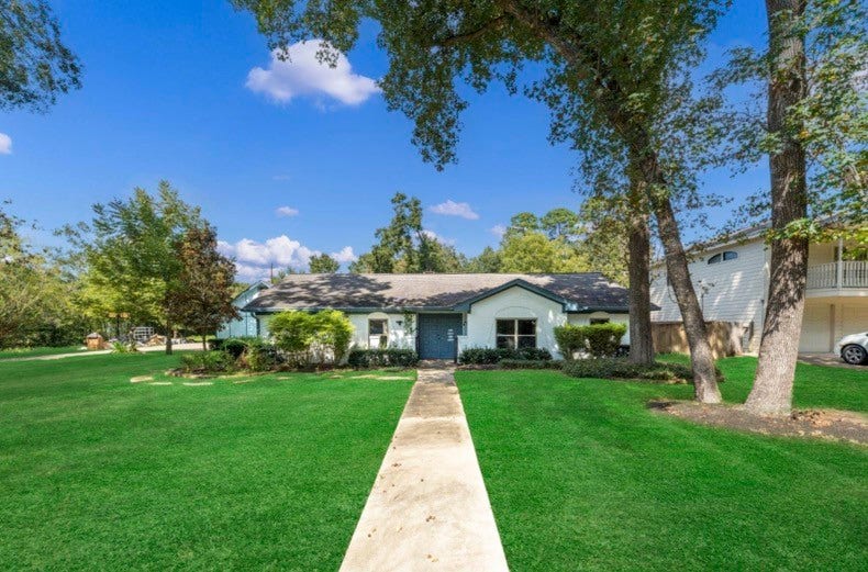 12710 Mutiny Lane, Tomball, TX 77377 A generous front lawn and mature trees frame the walkway to the home.
