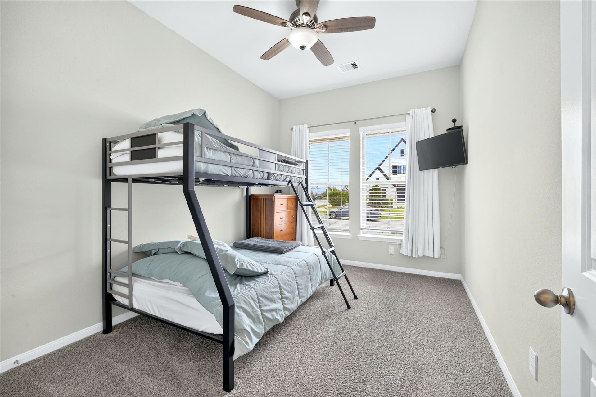 11351 Cosmopolitan Drive, Cypress, TX 77433 Front of the home bedroom featuring a large window, plush carpeting, ceiling fan, and a spacious walk-in closet. A bright and comfortable retreat with plenty of natural light and storage.