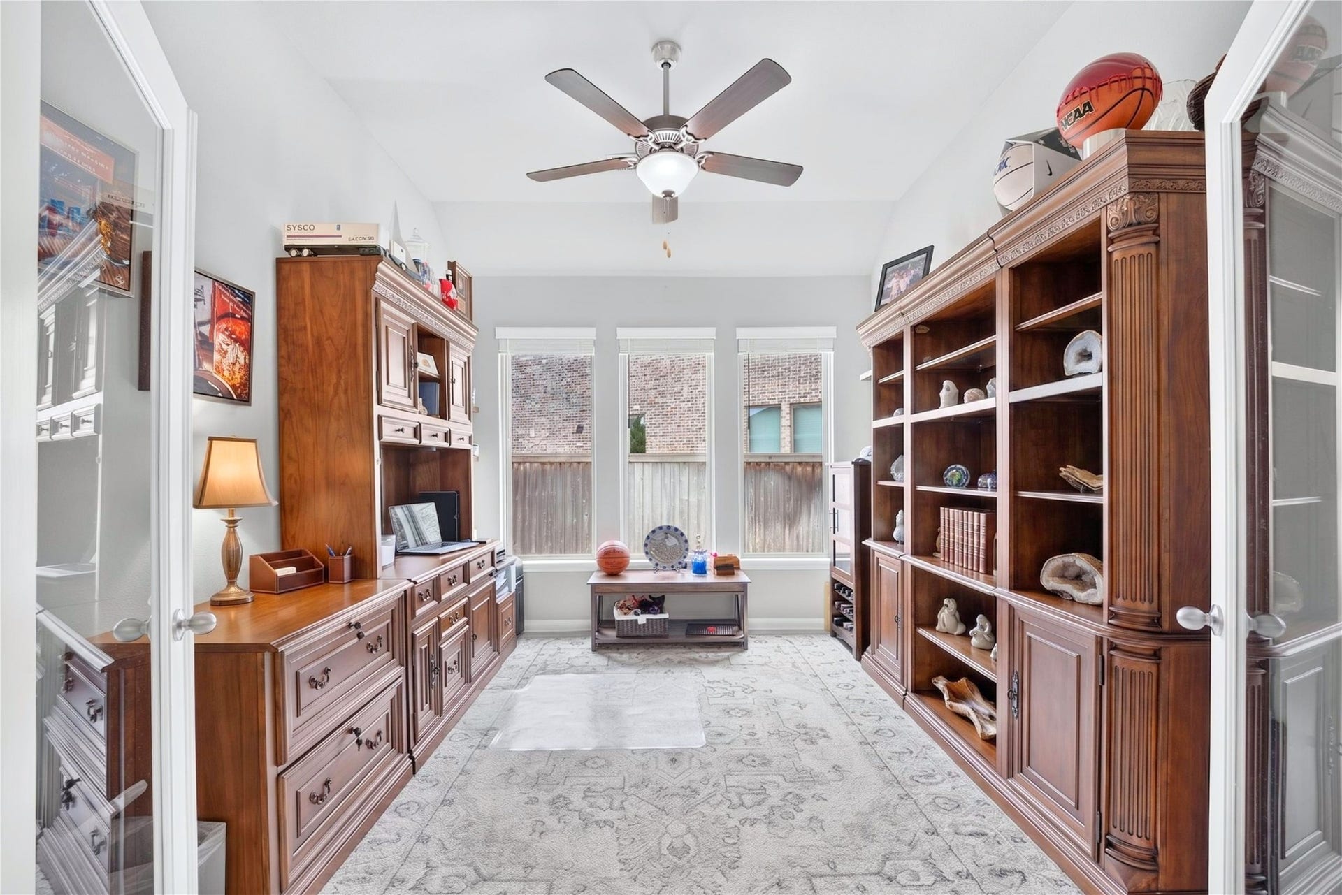 11351 Cosmopolitan Drive, Cypress, TX 77433 Private home office tucked toward the center of the home, featuring double glass doors and windows that bring in natural light.