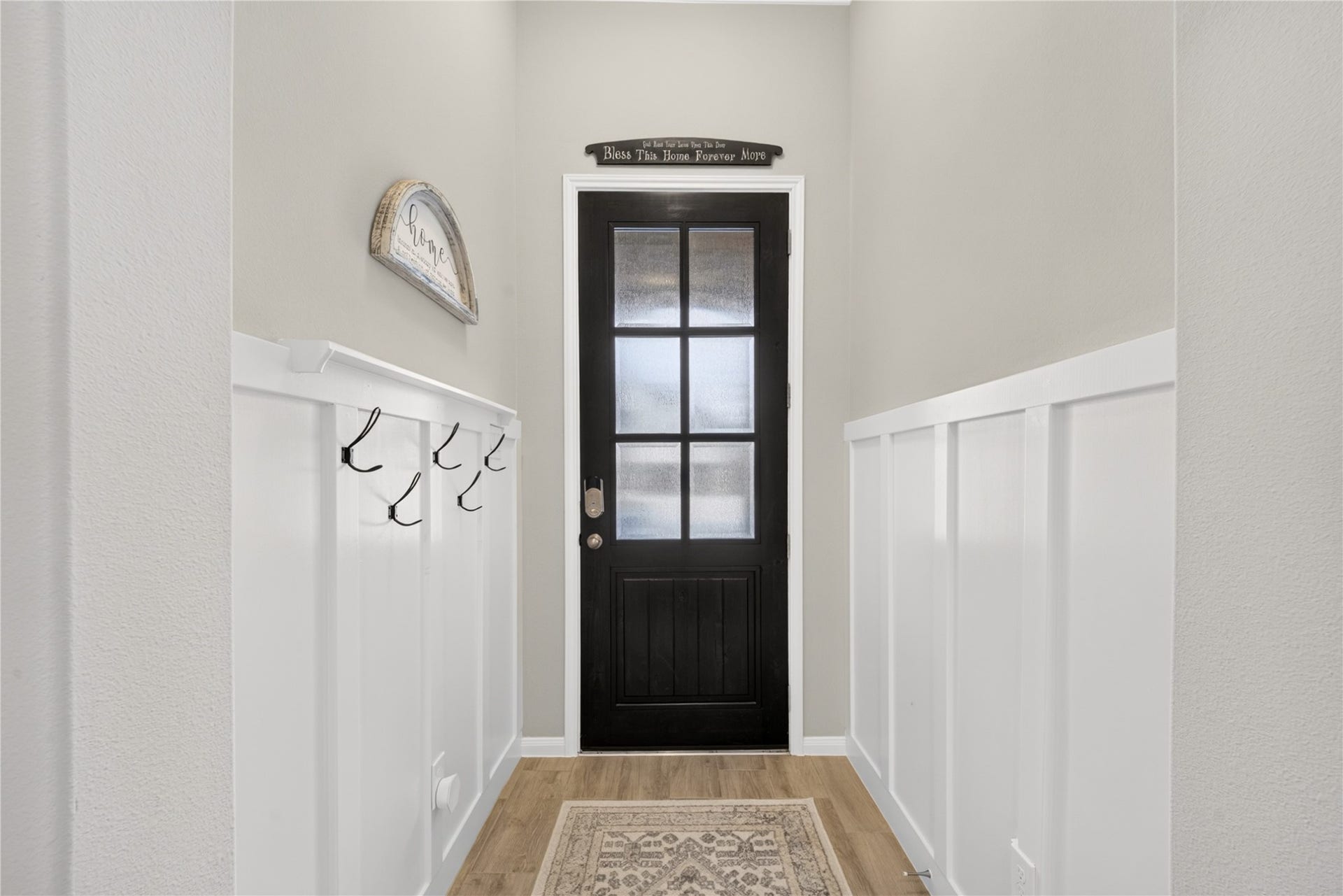 11351 Cosmopolitan Drive, Cypress, TX 77433 Welcoming hallway featuring beautiful white wainscoting, tile floors, stylish glass paneled front door. A convenient wall mounted hook area adds practical storage for coats, purses and every day essentials.
