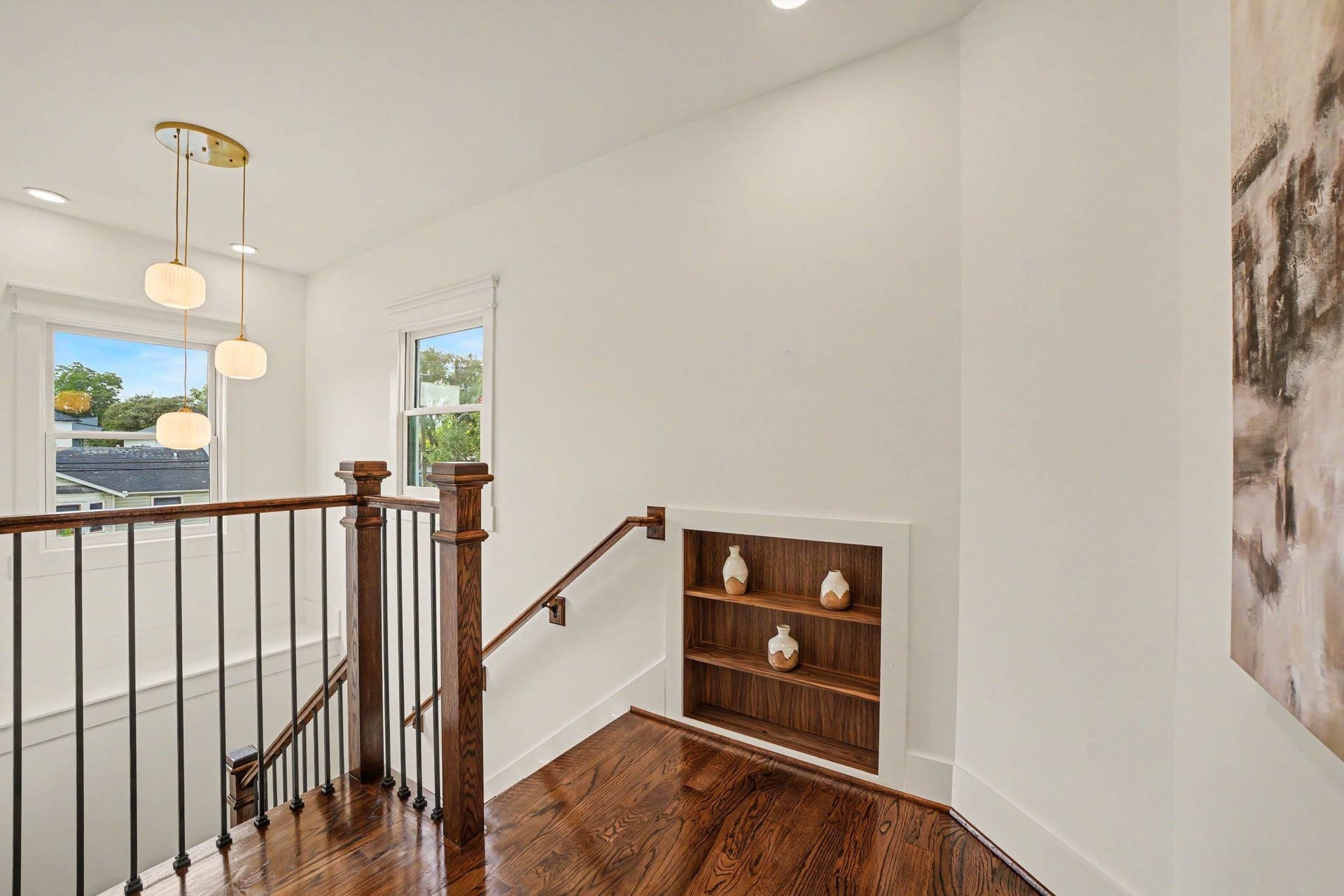Upstairs landing with gorgeous chandelier and hidden shelves giving access to attic storage space.
