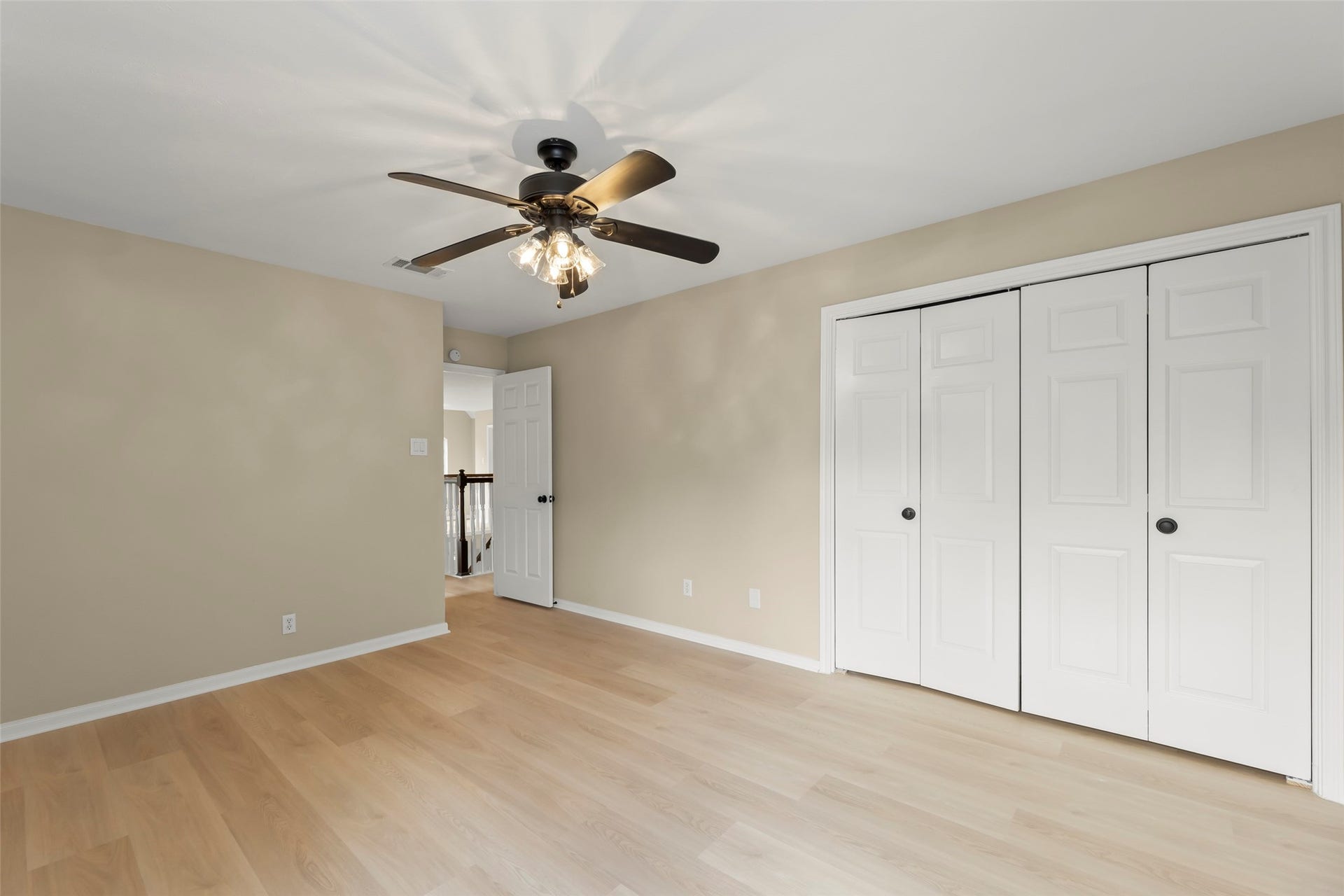 Double-door closet and an adjacent hallway. Ideal for a bedroom or office.