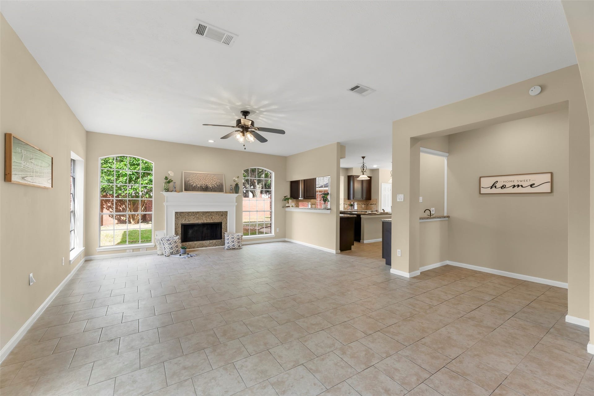 Flows into an open kitchen with modern fixtures, creating a warm and inviting space perfect for entertaining.