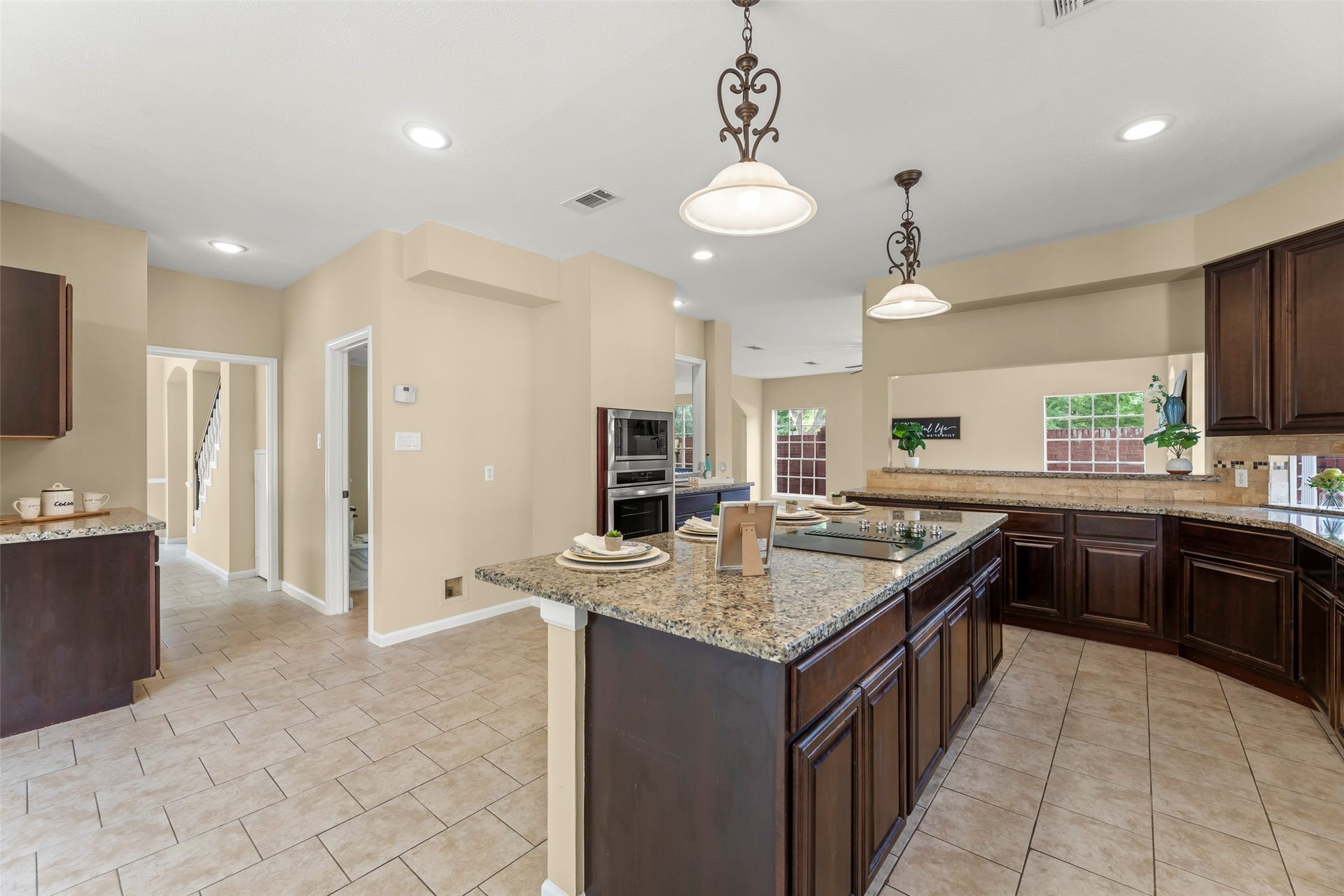Large island, modern appliances, and stylish pendant lighting. The open layout leads to the dining area, creating a warm, inviting space perfect for entertaining.