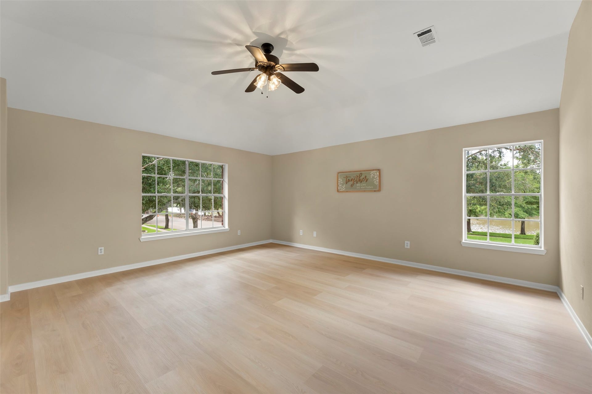 Large windows provide ample natural light and a view of the greenery outside.