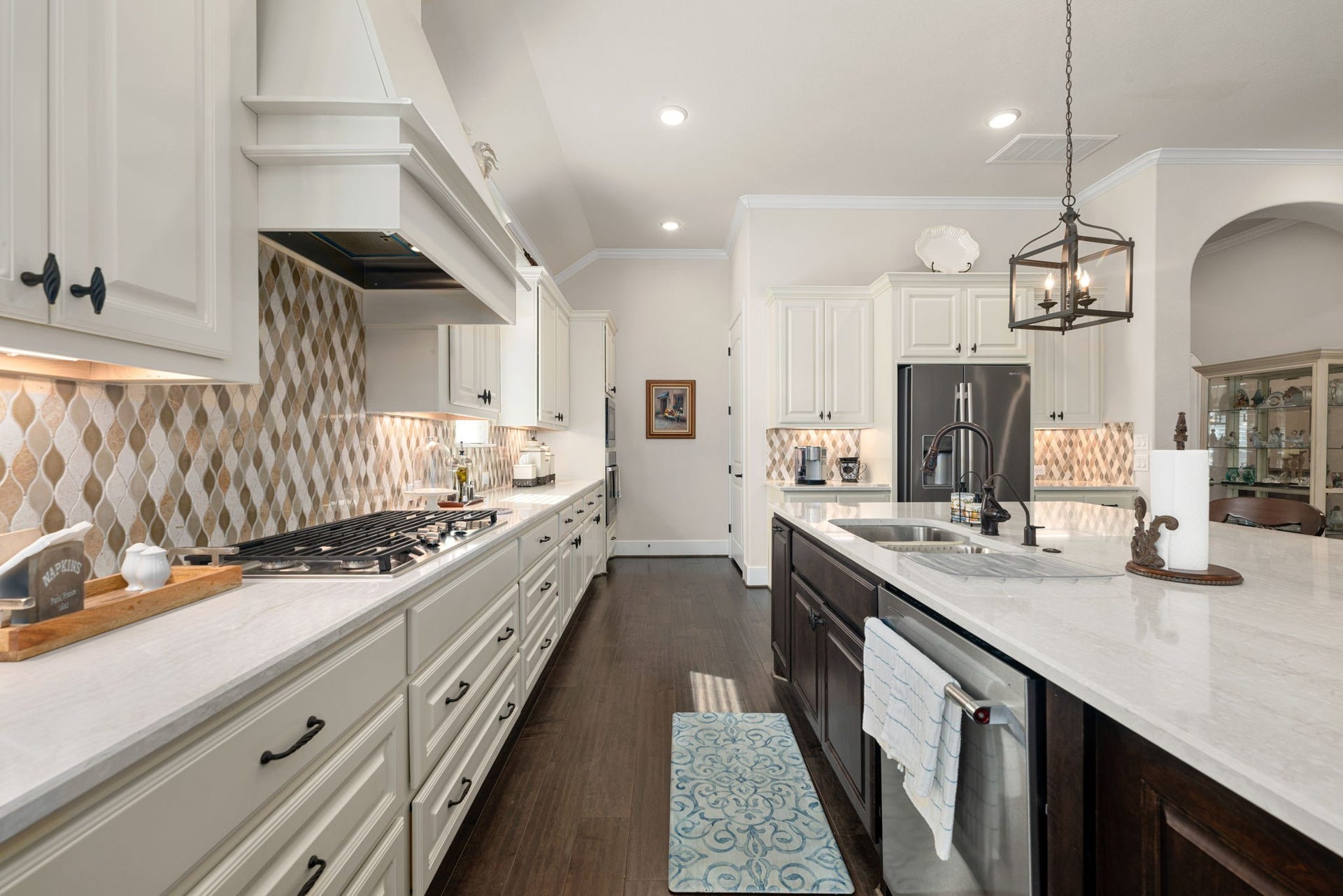 139 Dawning Rays Court, Conroe, TX 77304 Every detail shines in this gorgeous kitchen! Featuring a gas cooktop, designer backsplash, beautiful quartz countertops, abundant cabinetry, and an oversized island with a double sink and stainless steel dishwasher!