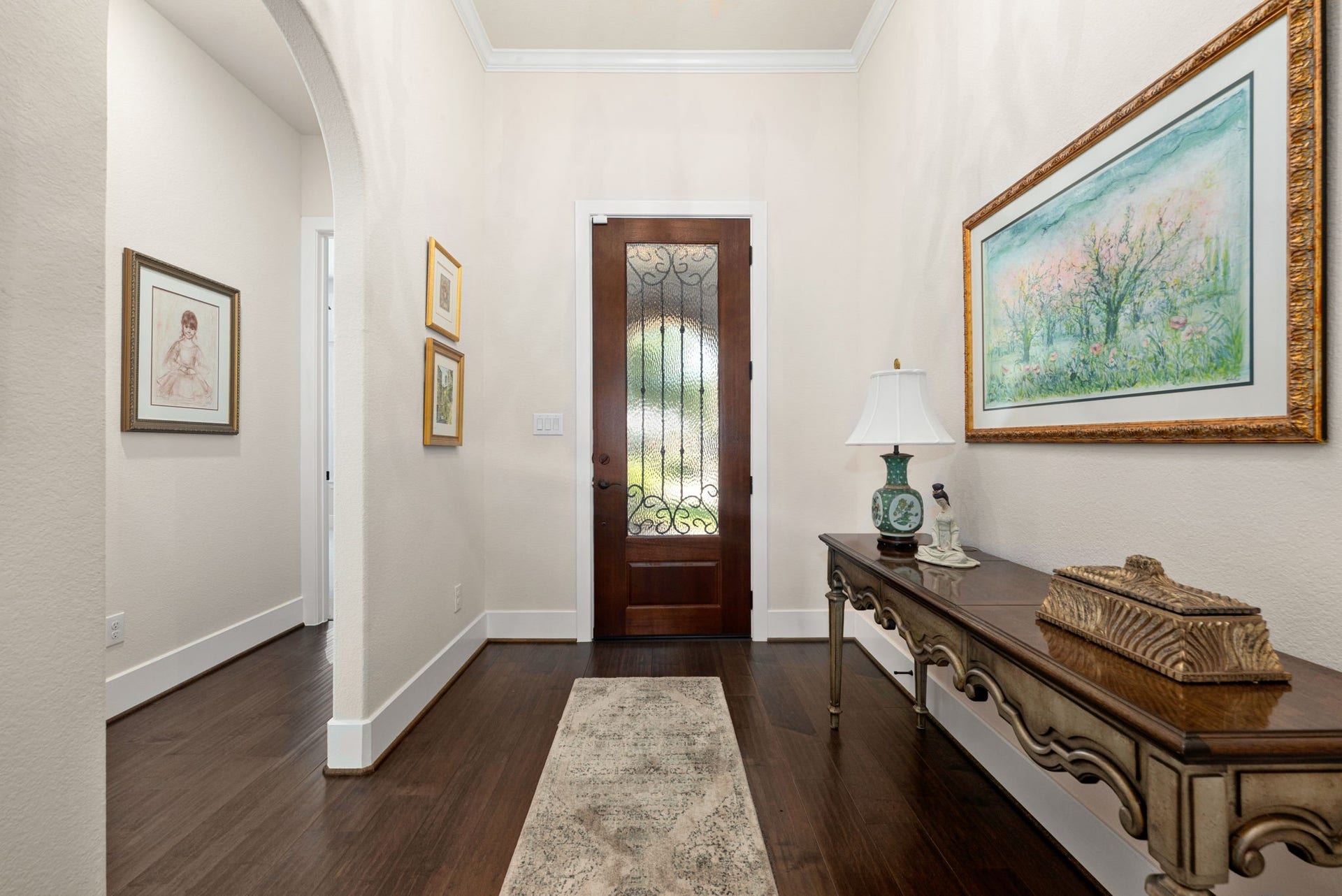 139 Dawning Rays Court, Conroe, TX 77304 A warm welcome awaits! This inviting entryway features beautiful wood flooring, elegant crown molding, and a graceful arched opening that sets the tone for the rest of the home.