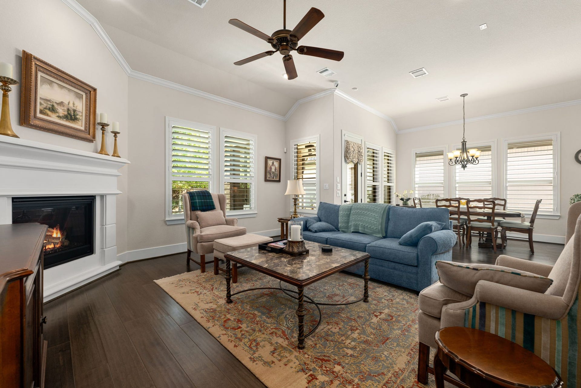 139 Dawning Rays Court, Conroe, TX 77304 Relax and unwind in this spacious, light-filled living room featuring soaring ceilings, beautiful wood flooring, a cozy fireplace, and plantation shutters.