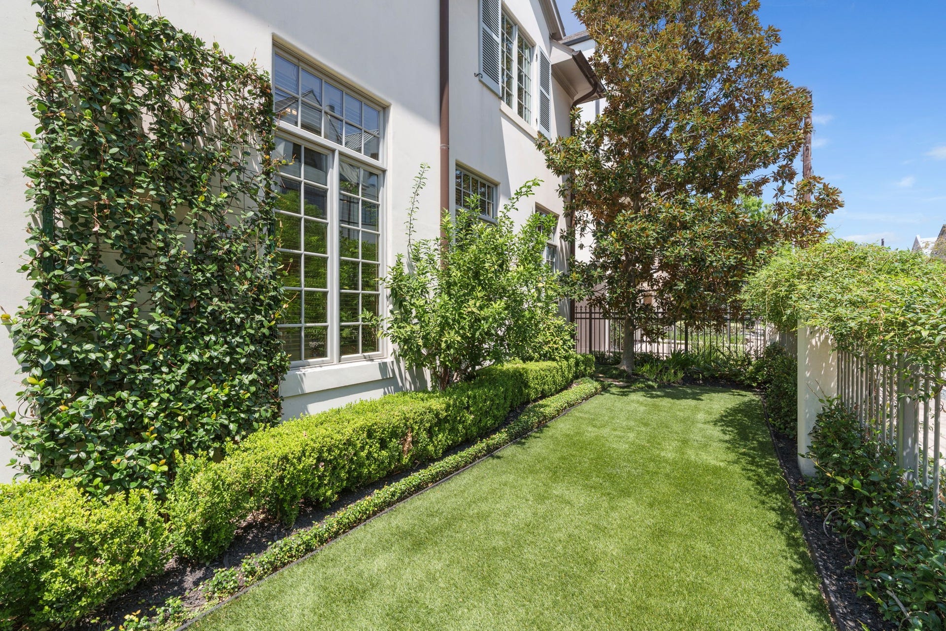 2820 Ferndale Street, Houston, TX 77098 Front Iron-Gated Turf Garden: Enclosed by classic wrought-iron fencing, the front lawn features premium artificial turf for year-round green appeal.