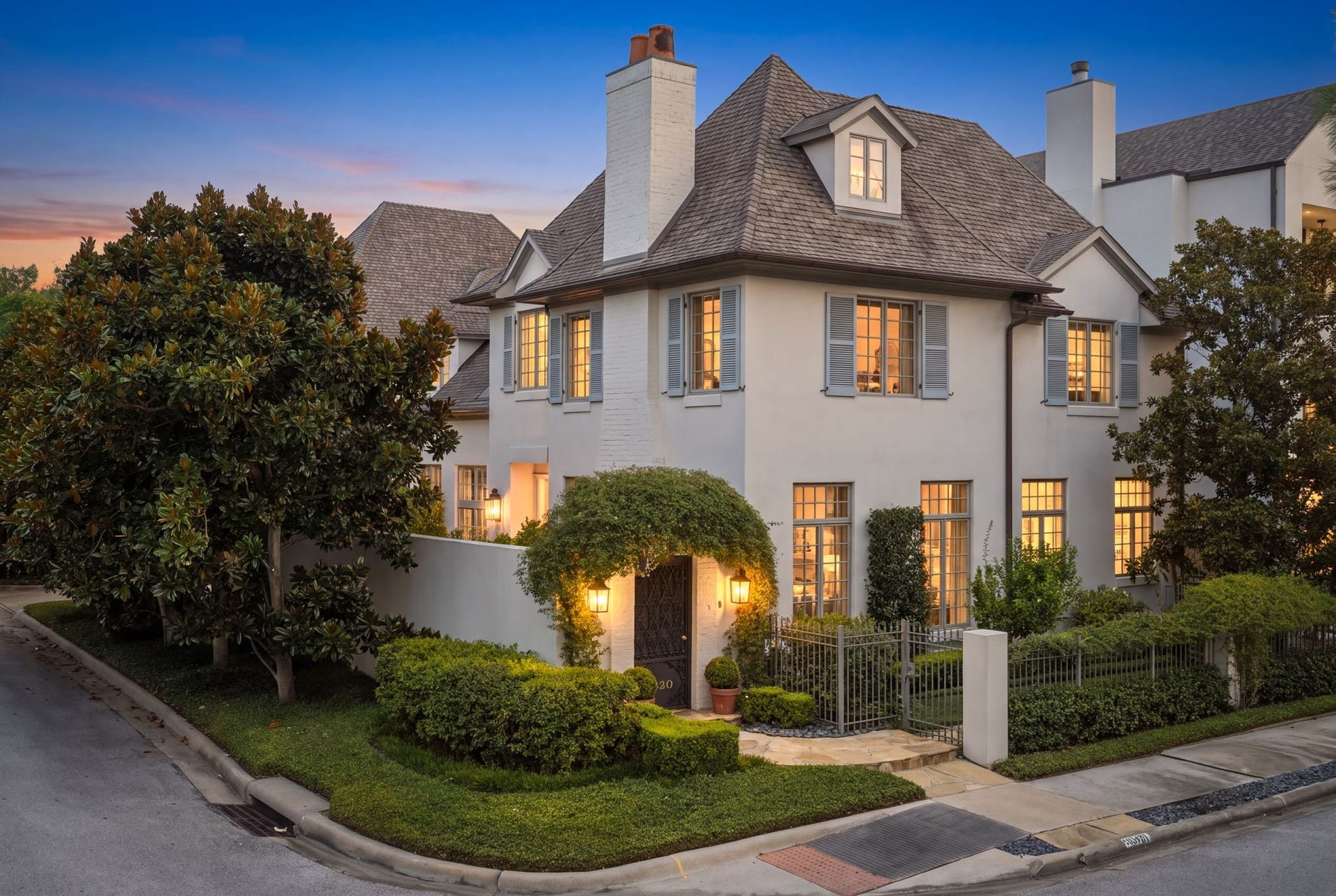2820 Ferndale Street, Houston, TX 77098 As twilight falls, exterior architectural lighting highlights the home's stucco facade architectural elements. This Kurt Aichler landmark stands as a one-of-a-kind Upper Kirby sanctuary.