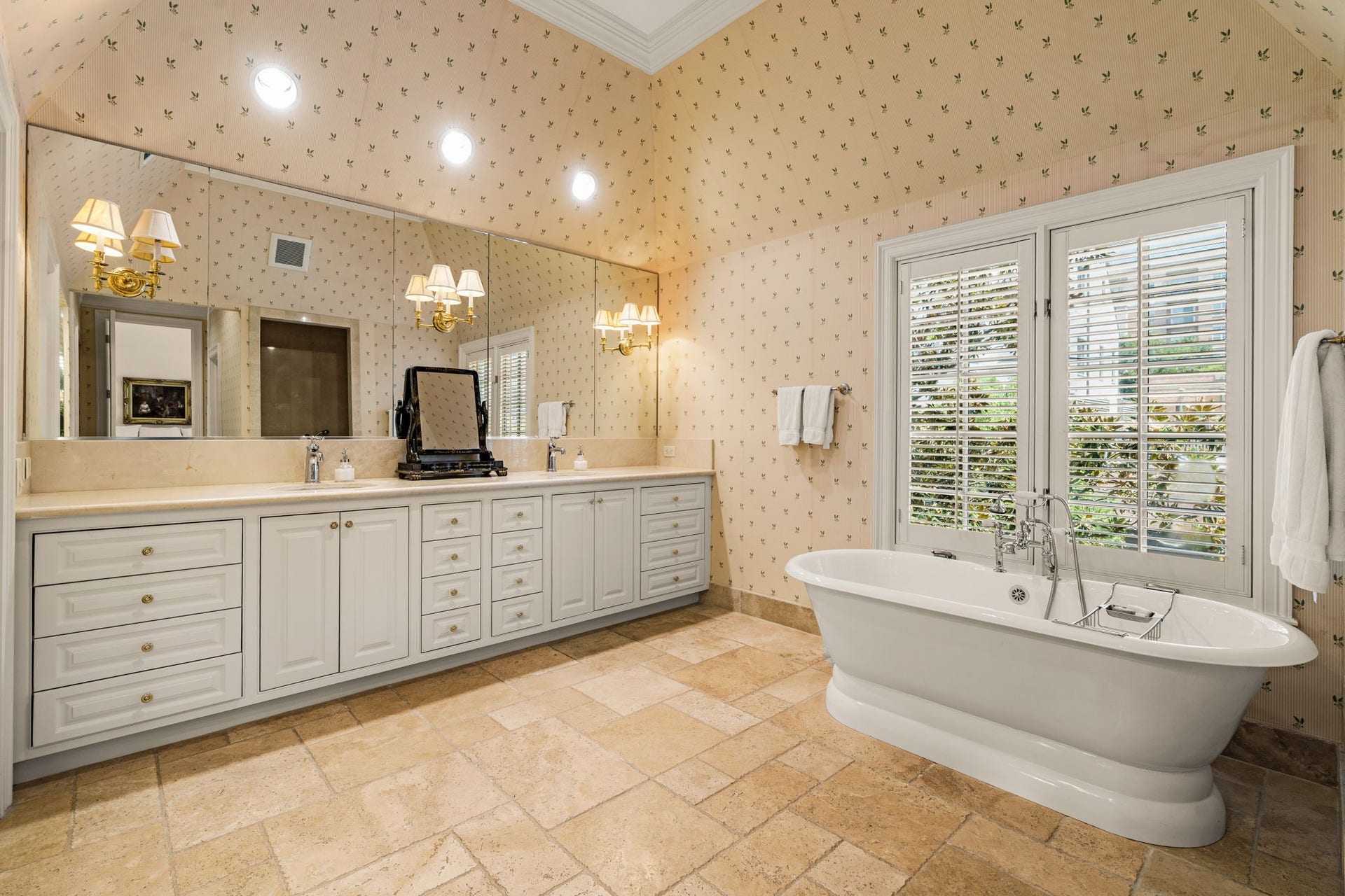 2820 Ferndale Street, Houston, TX 77098 Primary Bath: A deep soaking tub is set against stone surfaces and peaceful natural views. Designed for privacy and relaxation within the primary suite.