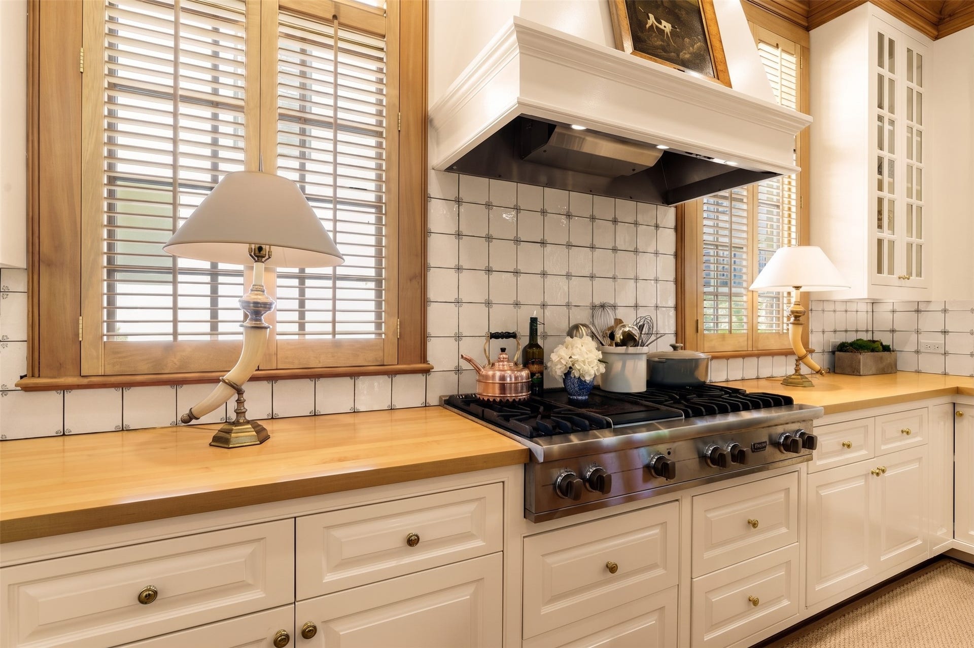 2820 Ferndale Street, Houston, TX 77098 Viking Range & Appliance Suite: Anchored by a Viking six-burner gas range with flat griddle and warming oven, this focal point highlights custom UK hand-painted tilework. Upper and lower cabinetry surround the cooking station.