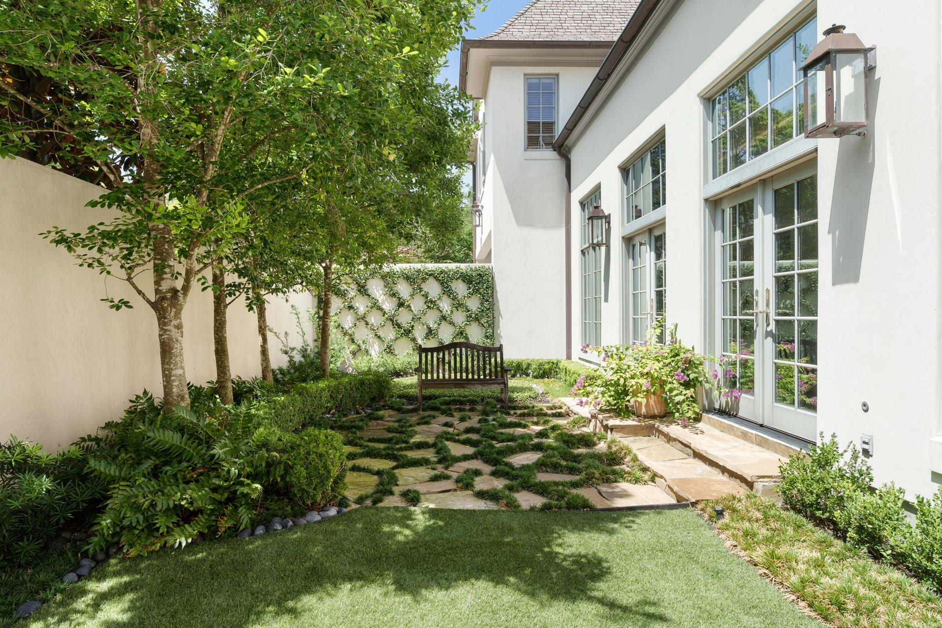 2820 Ferndale Street, Houston, TX 77098 Sunroom Gallery (Exterior Elevation): Two sets of French doors and expansive windows connect the interior gallery directly to the side grounds, creating a graceful transition between internal living spaces and the outdoors.