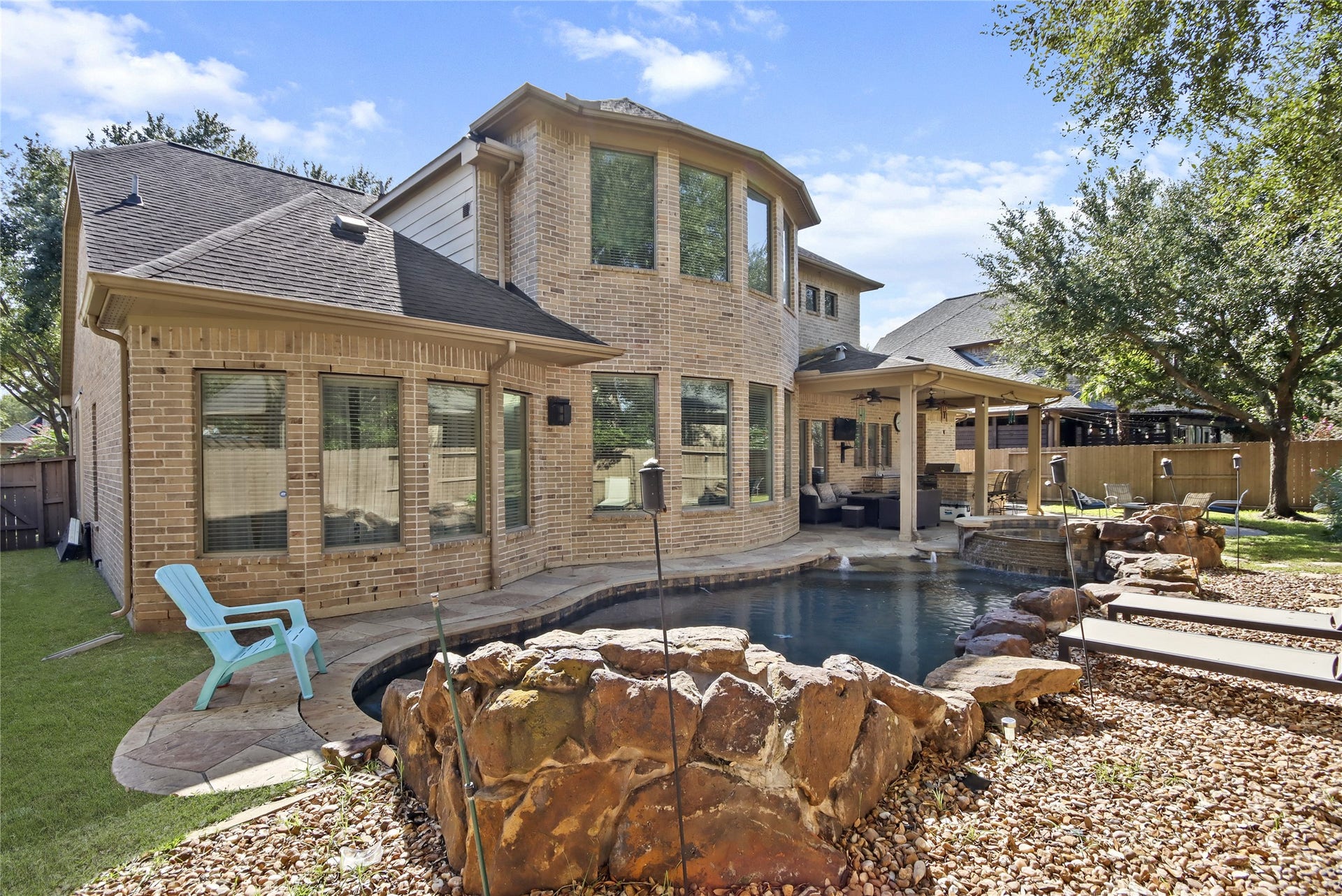 Your own backyard paradise awaits! Featuring sparkling pool, cascading rock waterfall, relaxing spa, and covered patio, this outdoor retreat is perfect for entertaining or simply enjoying the comforts of home.