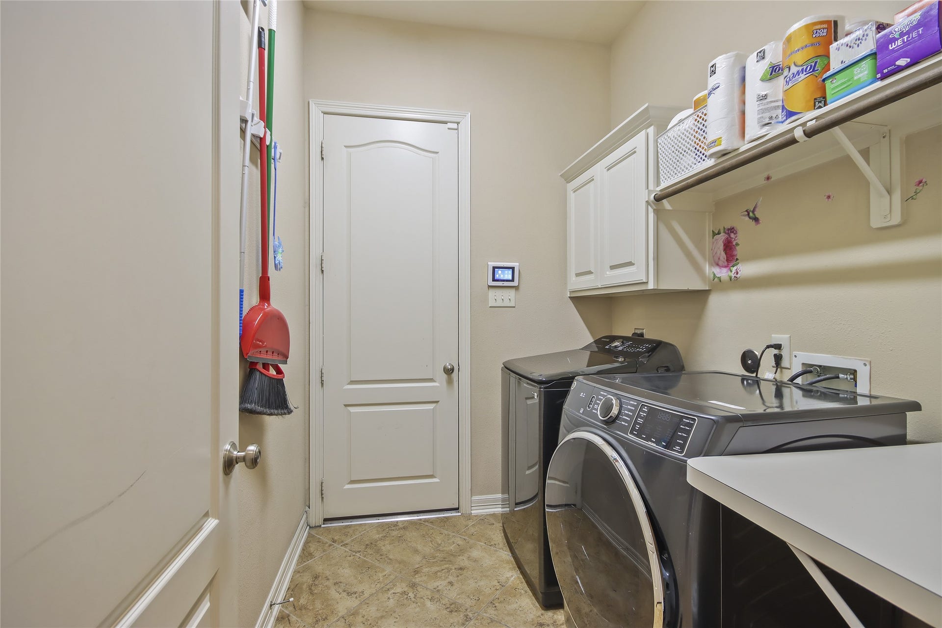 The laundry room is located downstairs. This laundry room features a handy folding table.