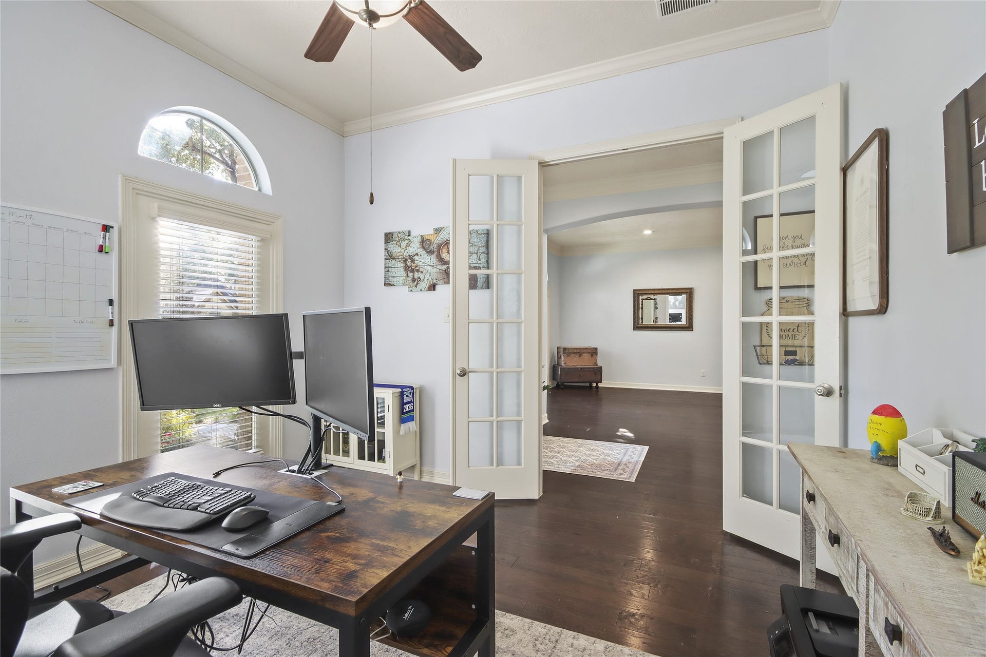 Stylish home office with glass french doors views into the spacious dinning area.