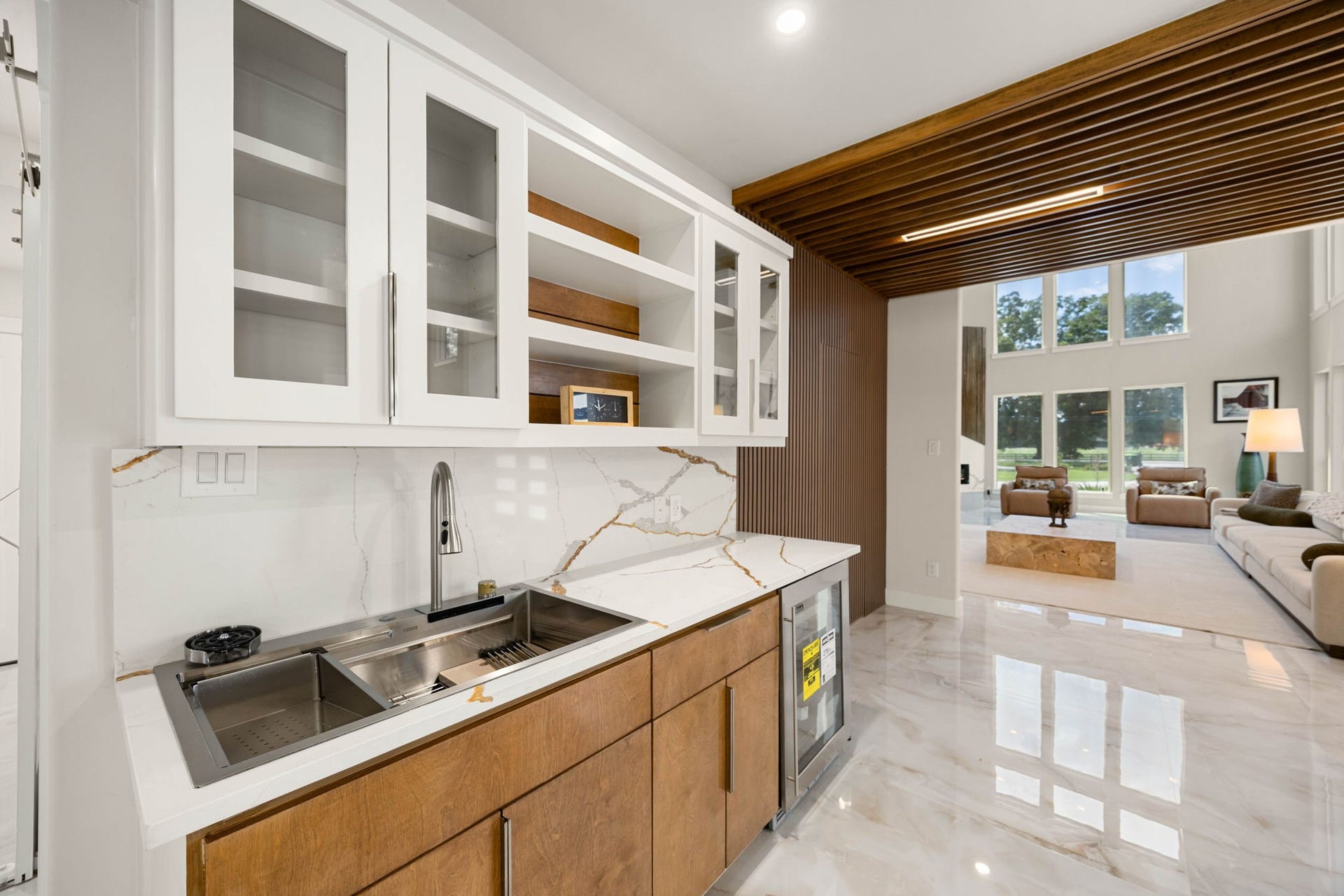 6830 Bois D Arc Lane, Fulshear, TX 77406 A dedicated wet bar with a wine fridge and marble countertop makes entertaining effortless, just steps from the main living area.