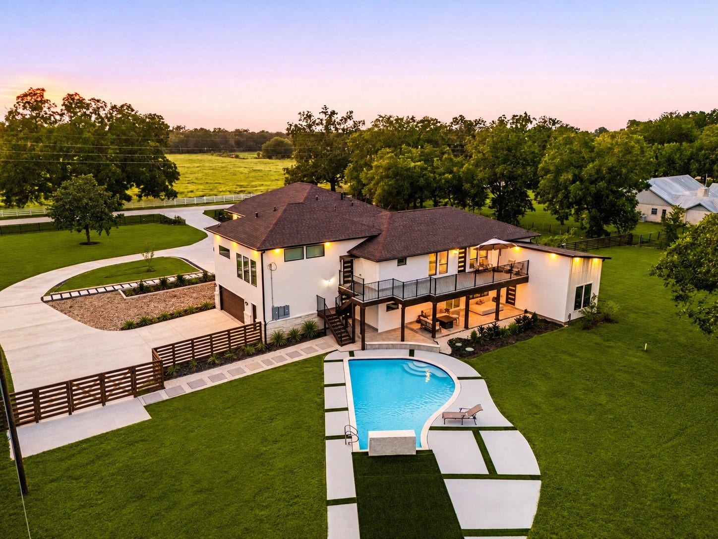 6830 Bois D Arc Lane, Fulshear, TX 77406 This aerial view captures the full scope of the backyard the pool, covered patio, and balcony overlooking the surrounding grounds.
