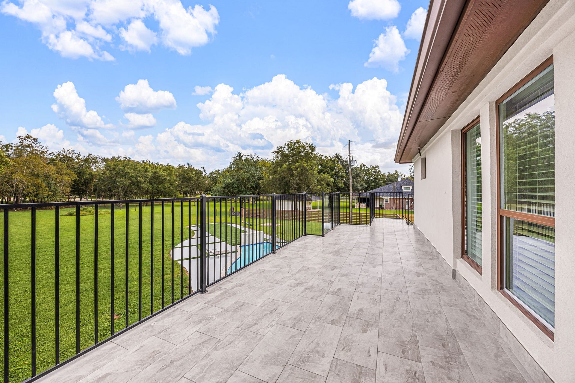 6830 Bois D Arc Lane, Fulshear, TX 77406 A spacious upstairs balcony offers sweeping views of the pool and expansive backyard below.
