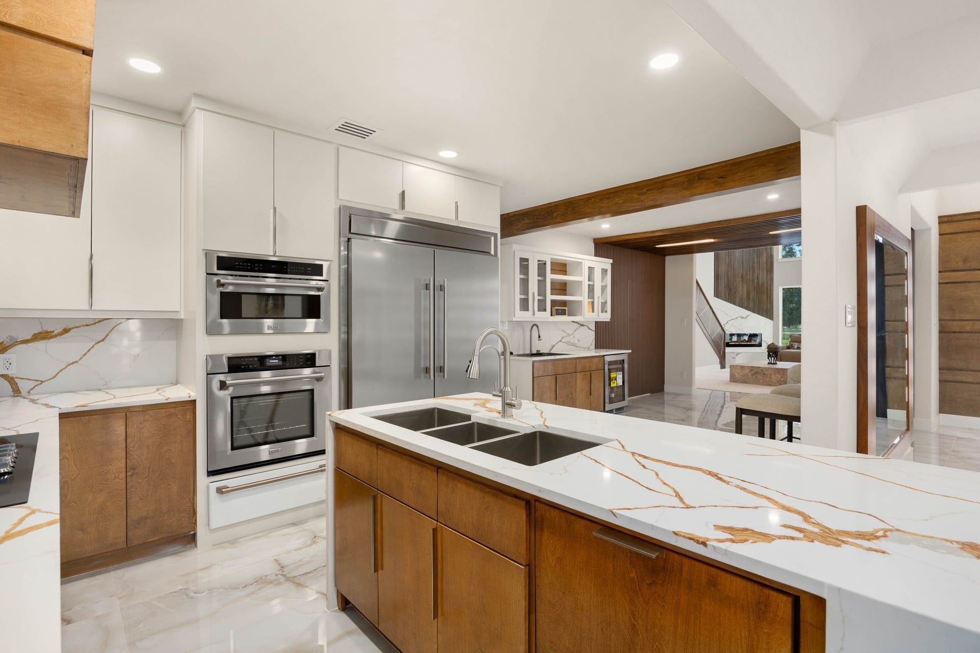 6830 Bois D Arc Lane, Fulshear, TX 77406 The kitchen flows effortlessly toward the wet bar and living area beyond, keeping the home's most-used spaces connected.