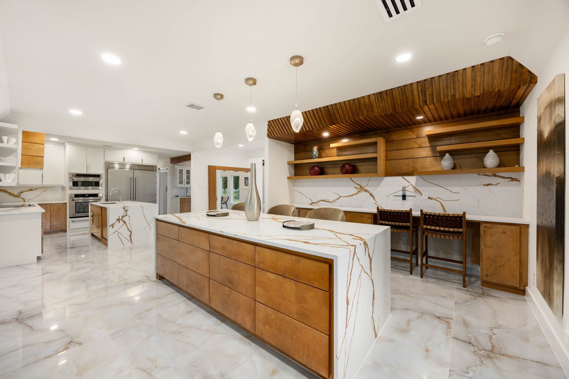 6830 Bois D Arc Lane, Fulshear, TX 77406 Just off the kitchen, the breakfast area pairs open wood shelving and marble slab detailing with warm pendant lighting an inviting spot for casual mornings.
