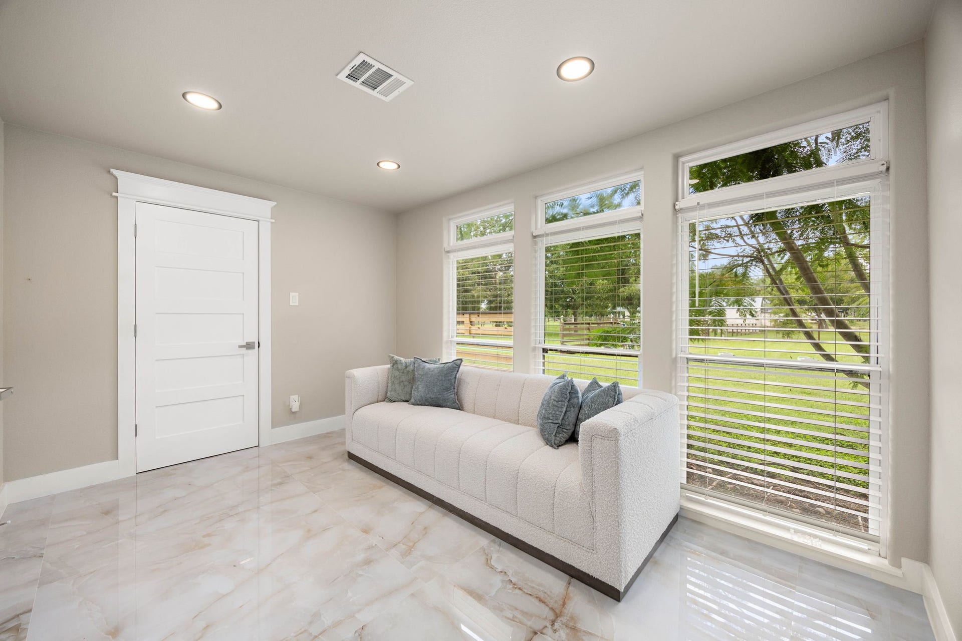 6830 Bois D Arc Lane, Fulshear, TX 77406 The suite's sitting area offers a flexible retreat, with shutters and picture windows framing the private grounds beyond.