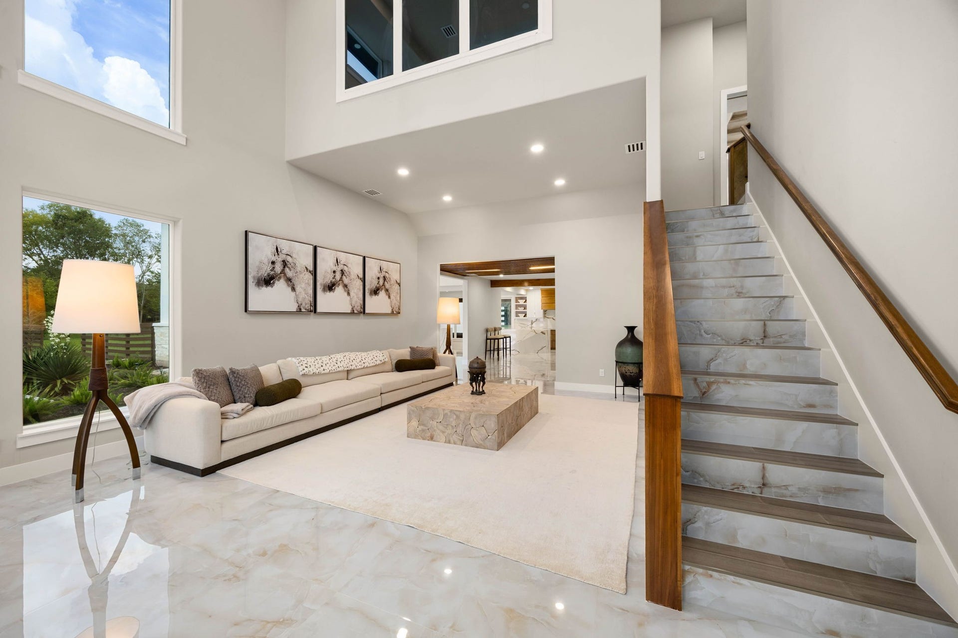 6830 Bois D Arc Lane, Fulshear, TX 77406 The main living space pairs a plush sectional with marble flooring and an open staircase, creating an easy flow between floors.