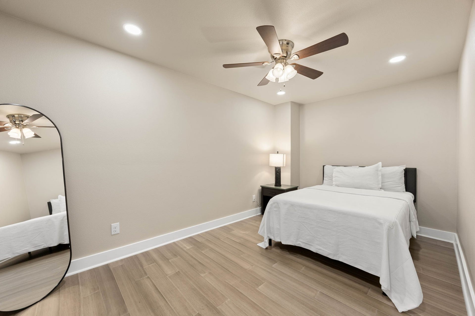6830 Bois D Arc Lane, Fulshear, TX 77406 This secondary bedroom offers a soft green color palette, a ceiling fan, and warm wood-tone flooring for a calm, restful feel.