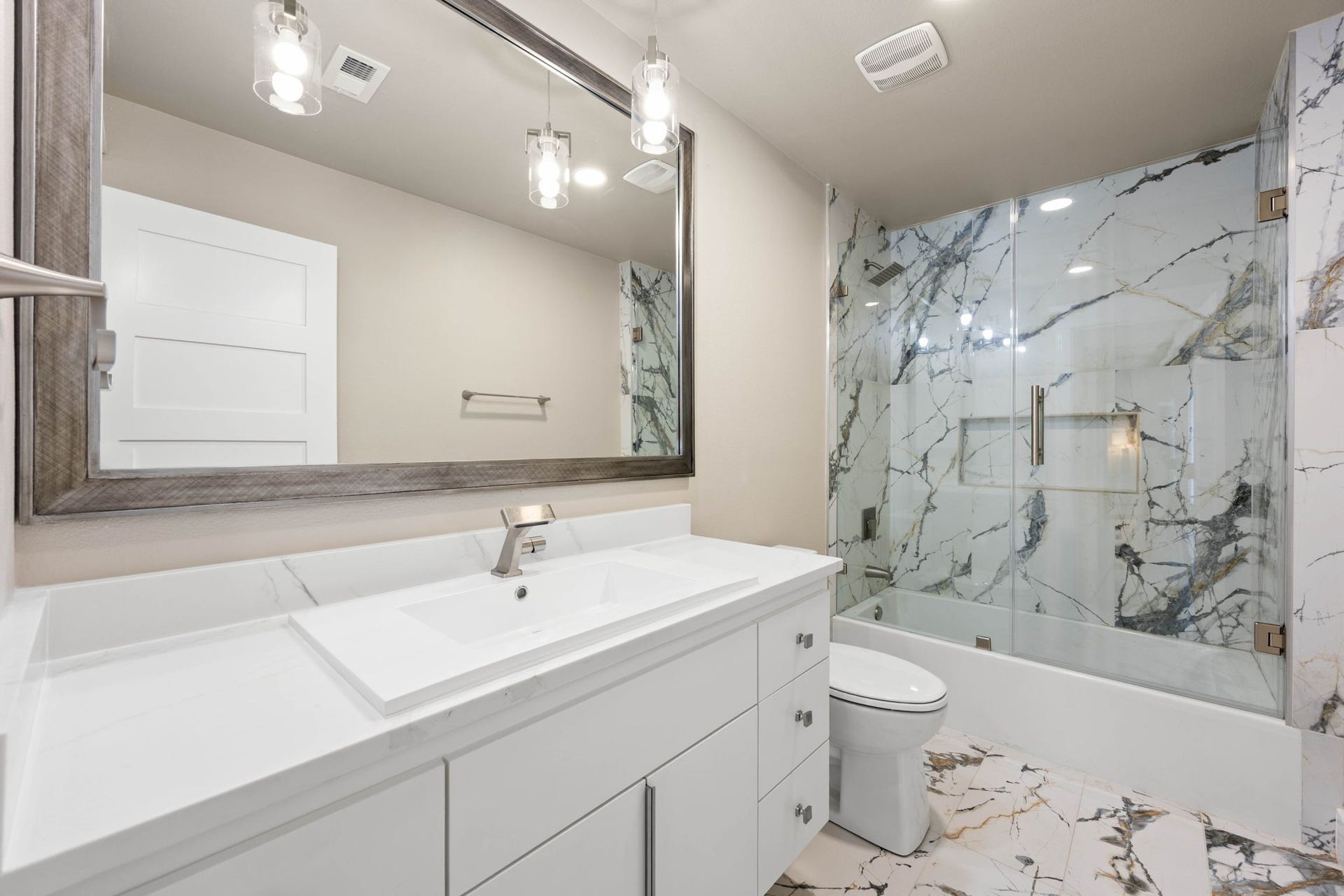 6830 Bois D Arc Lane, Fulshear, TX 77406 The adjoining secondary bath continues the tub-shower combination design with natural stone tile flooring and a private window.