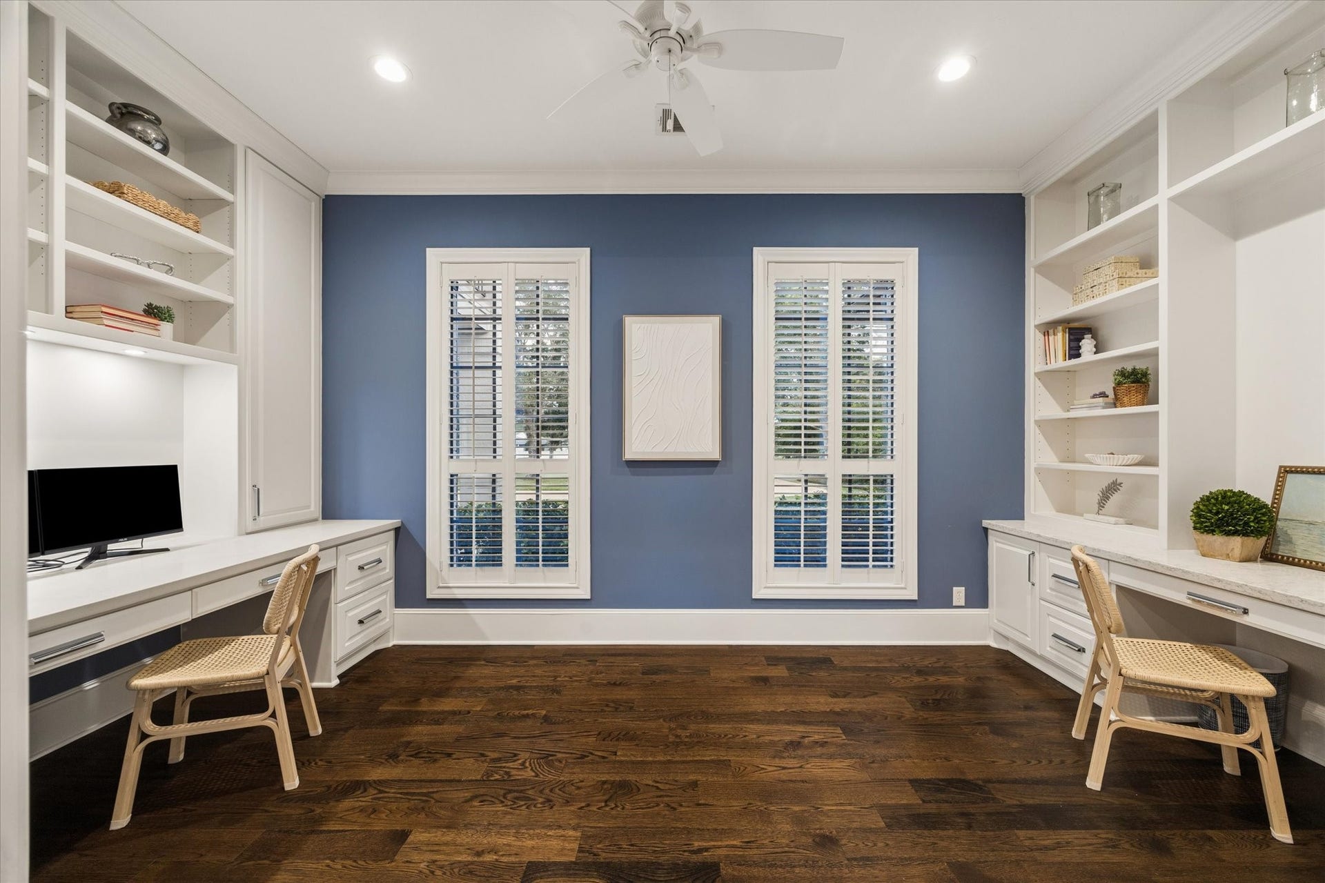 Spacious study featuring custom built-ins with integrated shelving and elegant French doors, offering a perfect blend of privacy and sophisticated organization.