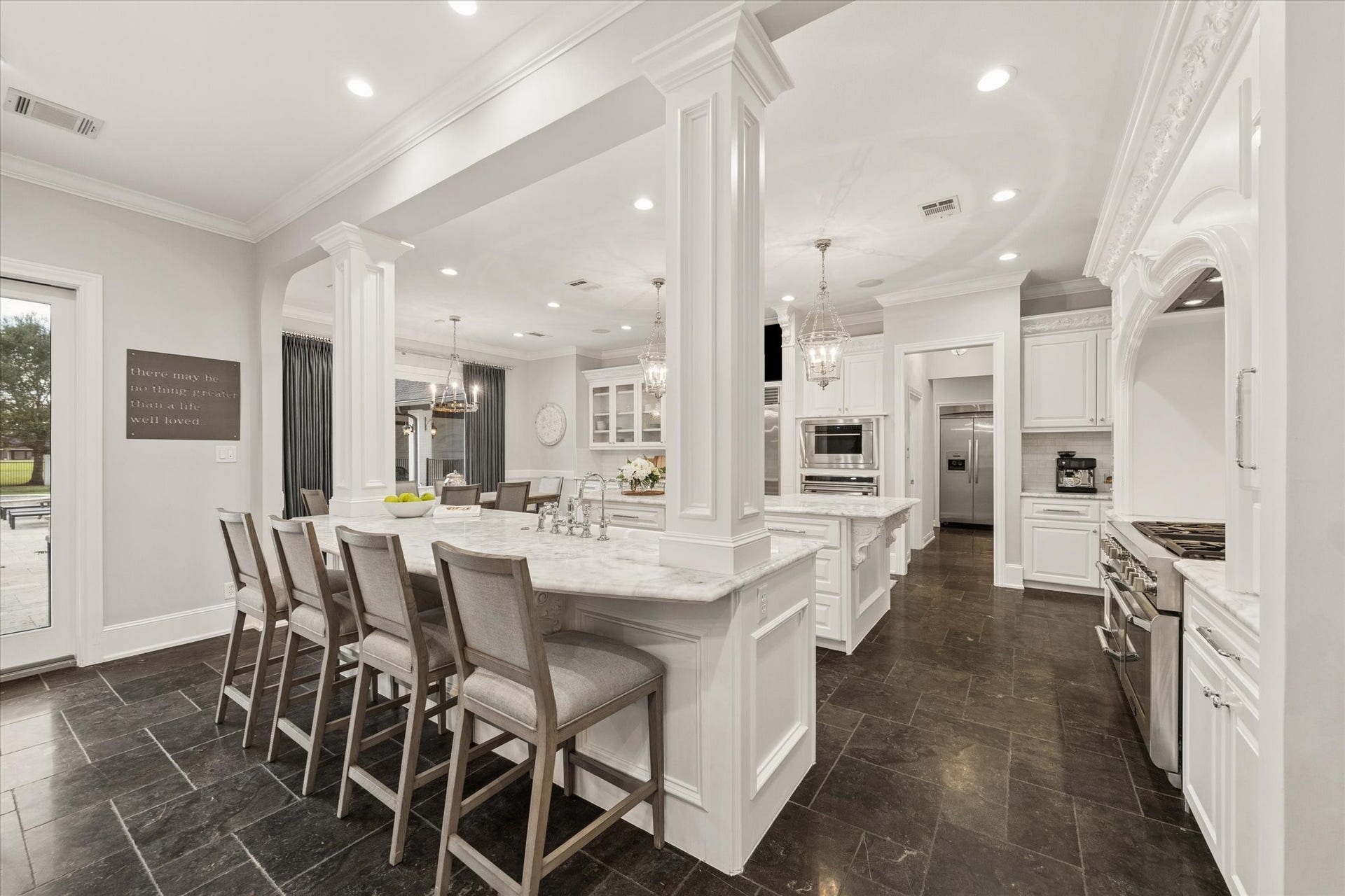 Breakfast bar overlooking the kitchen, featuring two sinks and ample counter space.