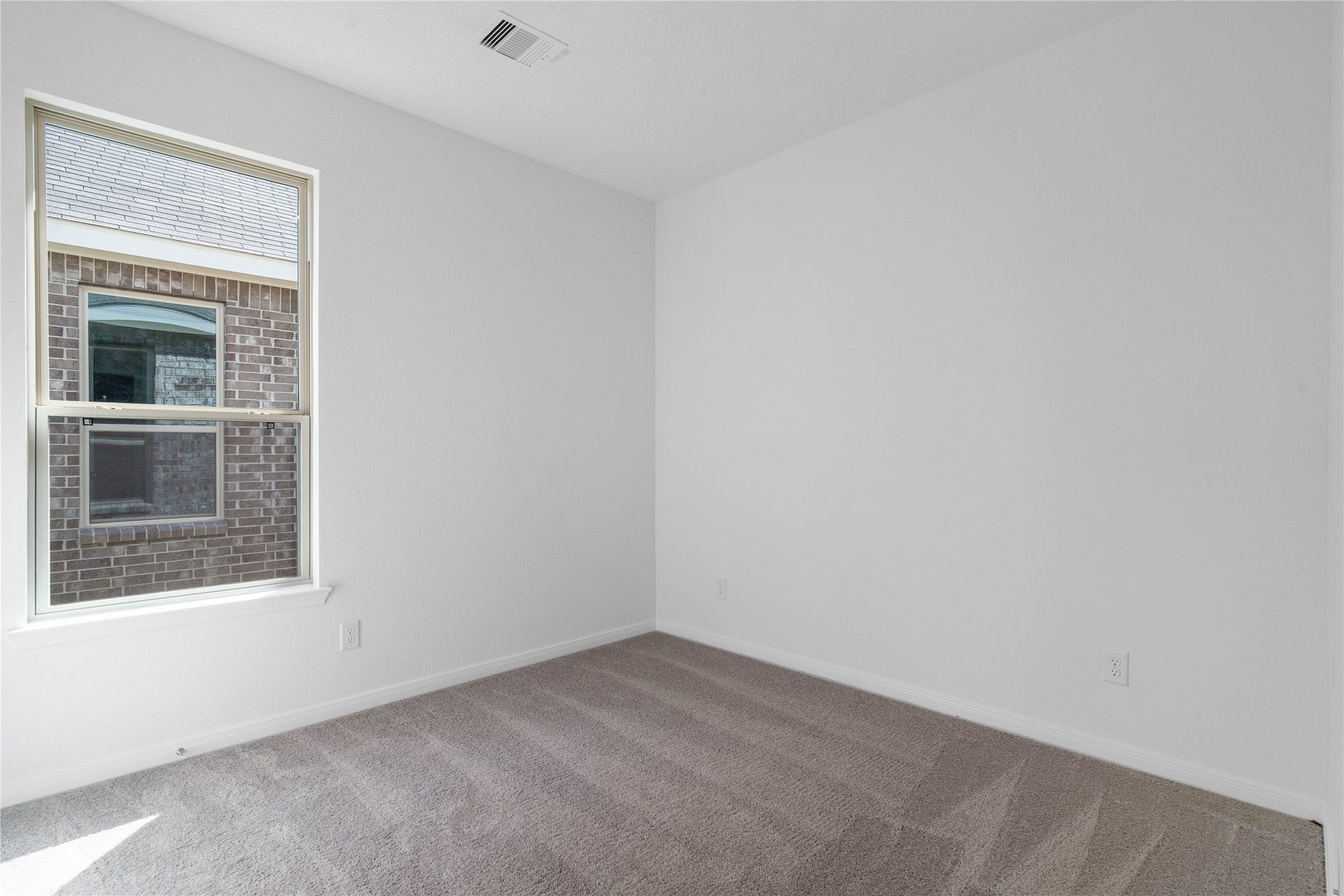 The handsome Den features plush carpet flooring, high ceilings, large window and neutral paint.