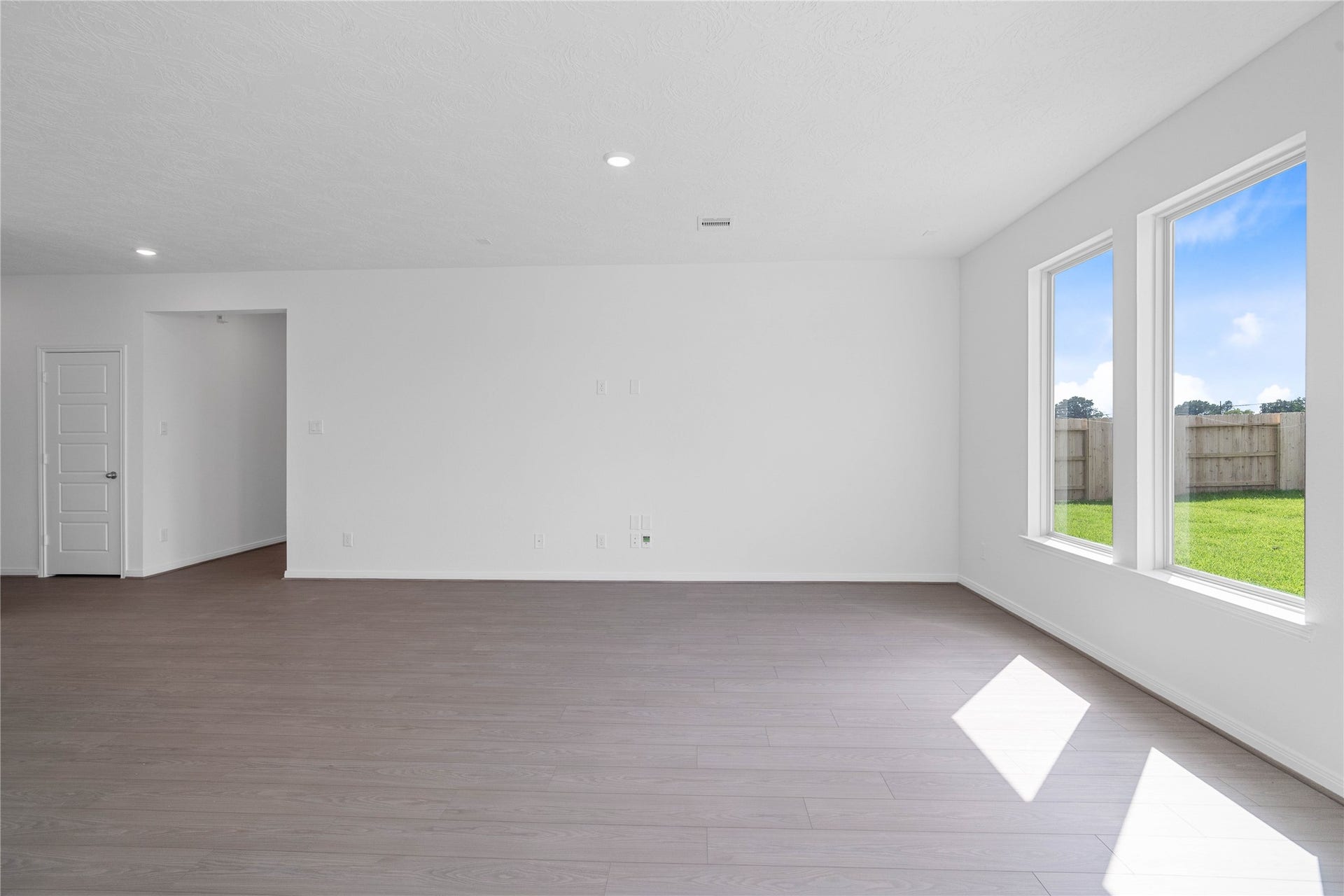 Bright and airy, this spacious Great Room serves as the perfect canvas for your personal style. A bank of large windows floods the space with abundant natural light, creating a warm and welcoming atmosphere. The clean lines and versatile layout offer endless possibilities for furniture arrangement and entertainment setup.