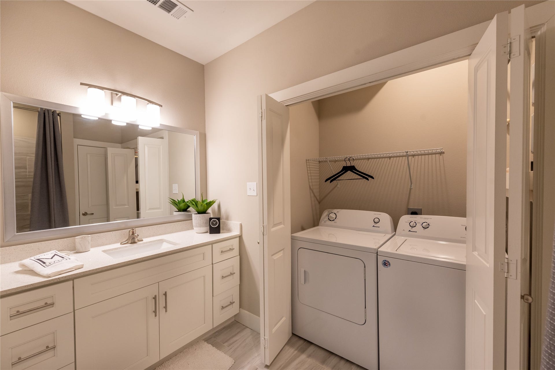 Full size Washer and Dryer convenient in-unit laundry area neatly tucked behind bi-fold doors.