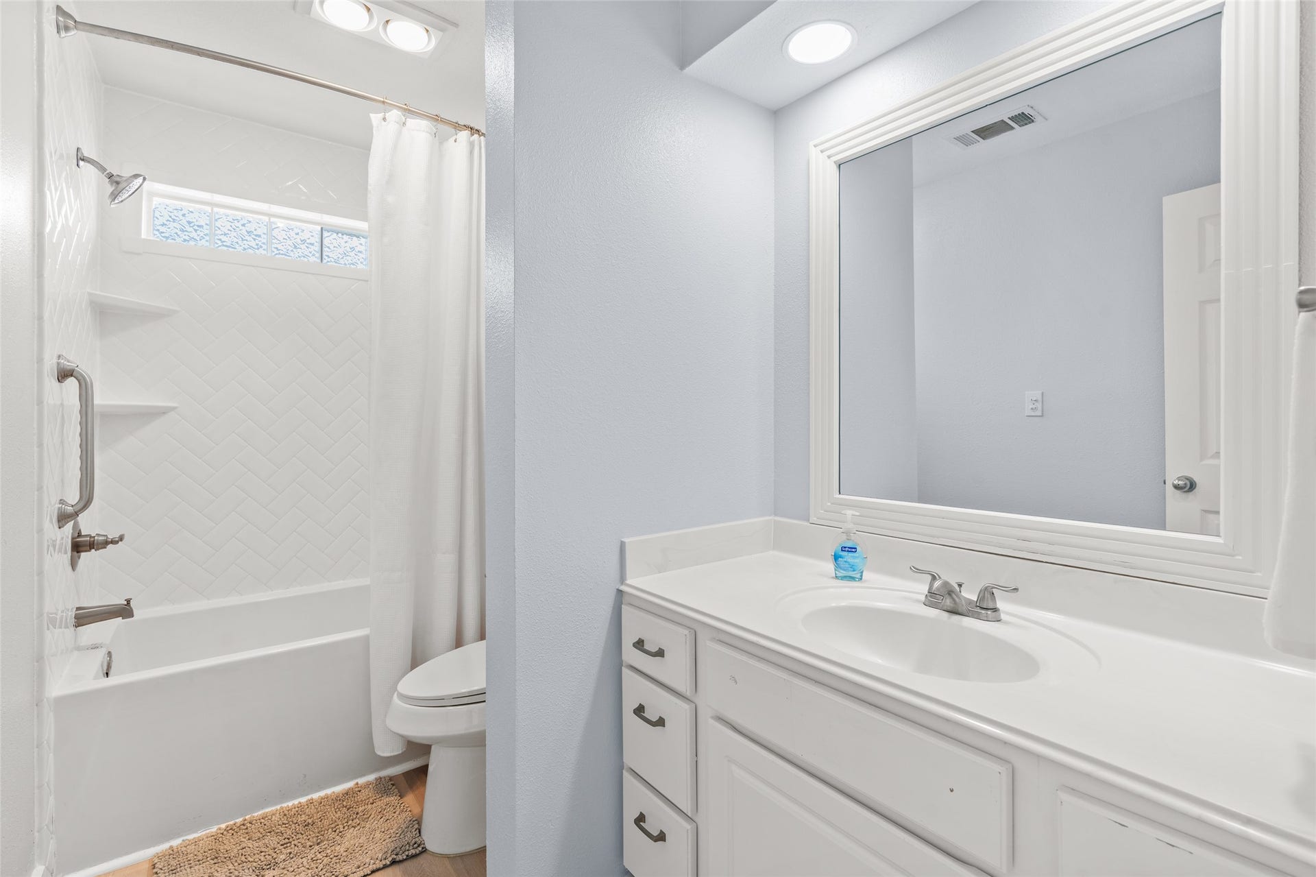 21631 Termini San Luis Pass Road, Galveston, TX 77554 Bathroom featuring a white vanity, large mirror, and a classic bathtub with elegant herringbone tile detail.