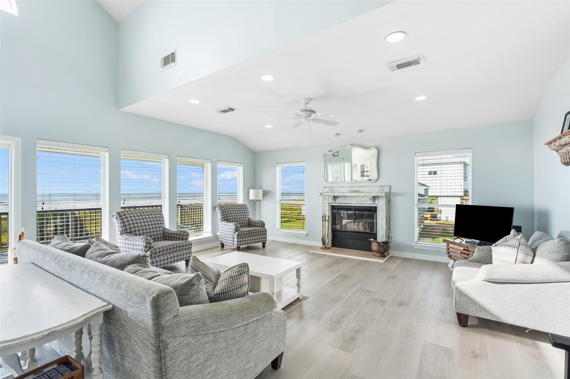 21631 Termini San Luis Pass Road, Galveston, TX 77554 Living room features large windows with ocean views, and a cozy fireplace, ideal for the winter days at the beach!