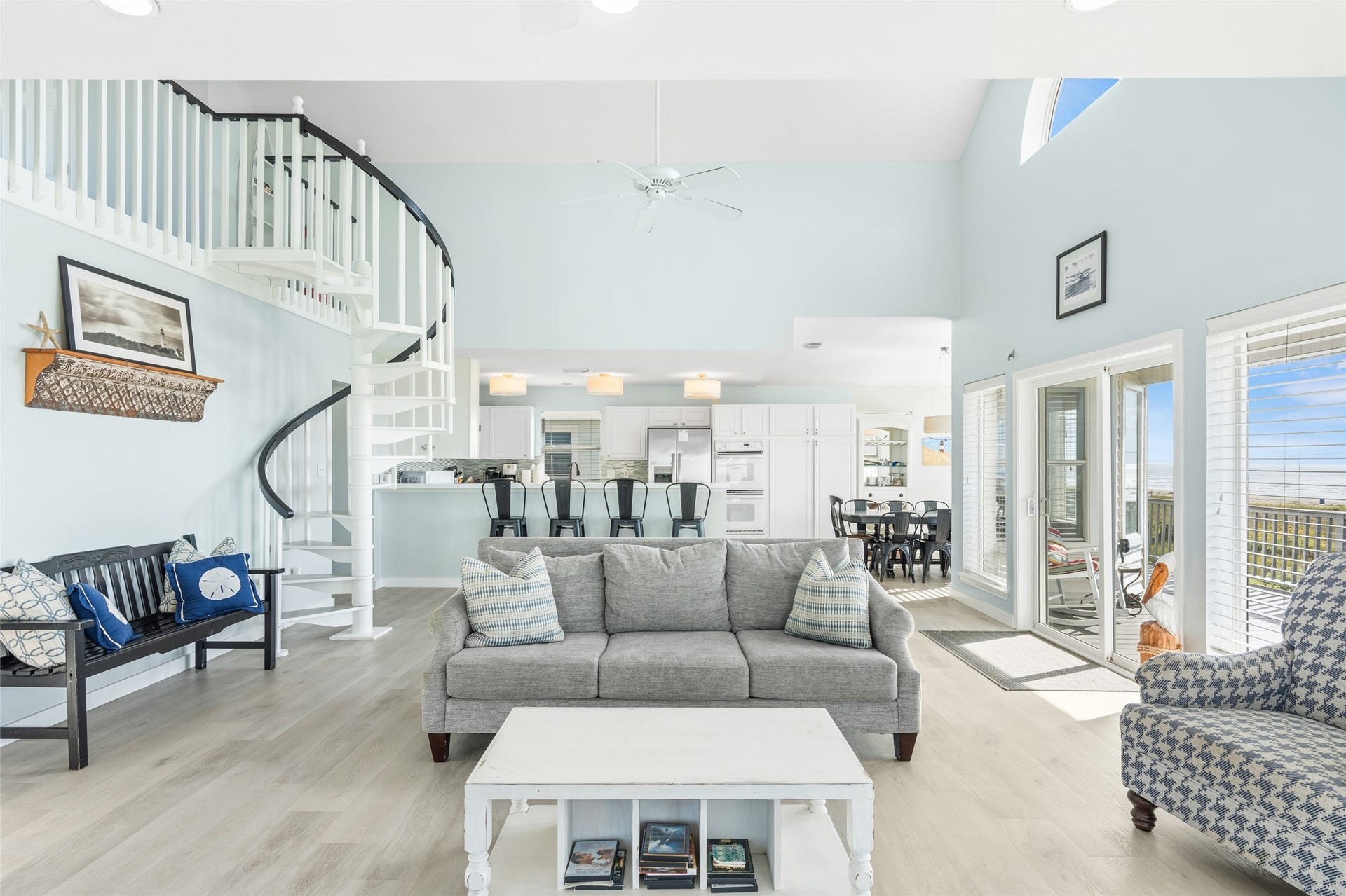 21631 Termini San Luis Pass Road, Galveston, TX 77554 Bright and airy living space with a spiral staircase, and an open-concept layout, featuring a cozy seating area and open to the kitchen with bar seating.