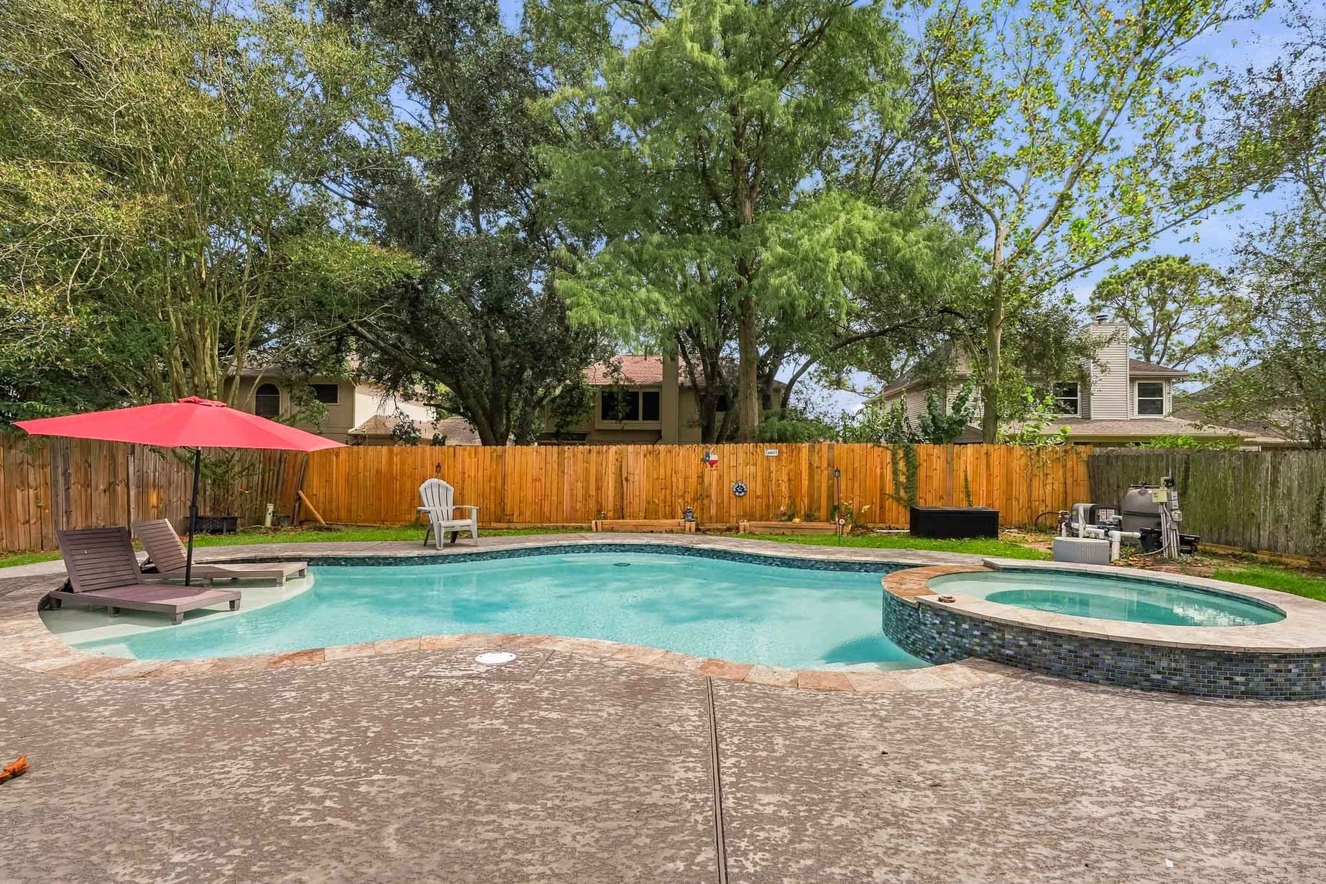 4811 Red Lantern Drive, Friendswood, TX 77546 Relax in a private backyard oasis featuring a beautiful pool and spa, perfect for entertaining or unwinding under the shade of mature trees.