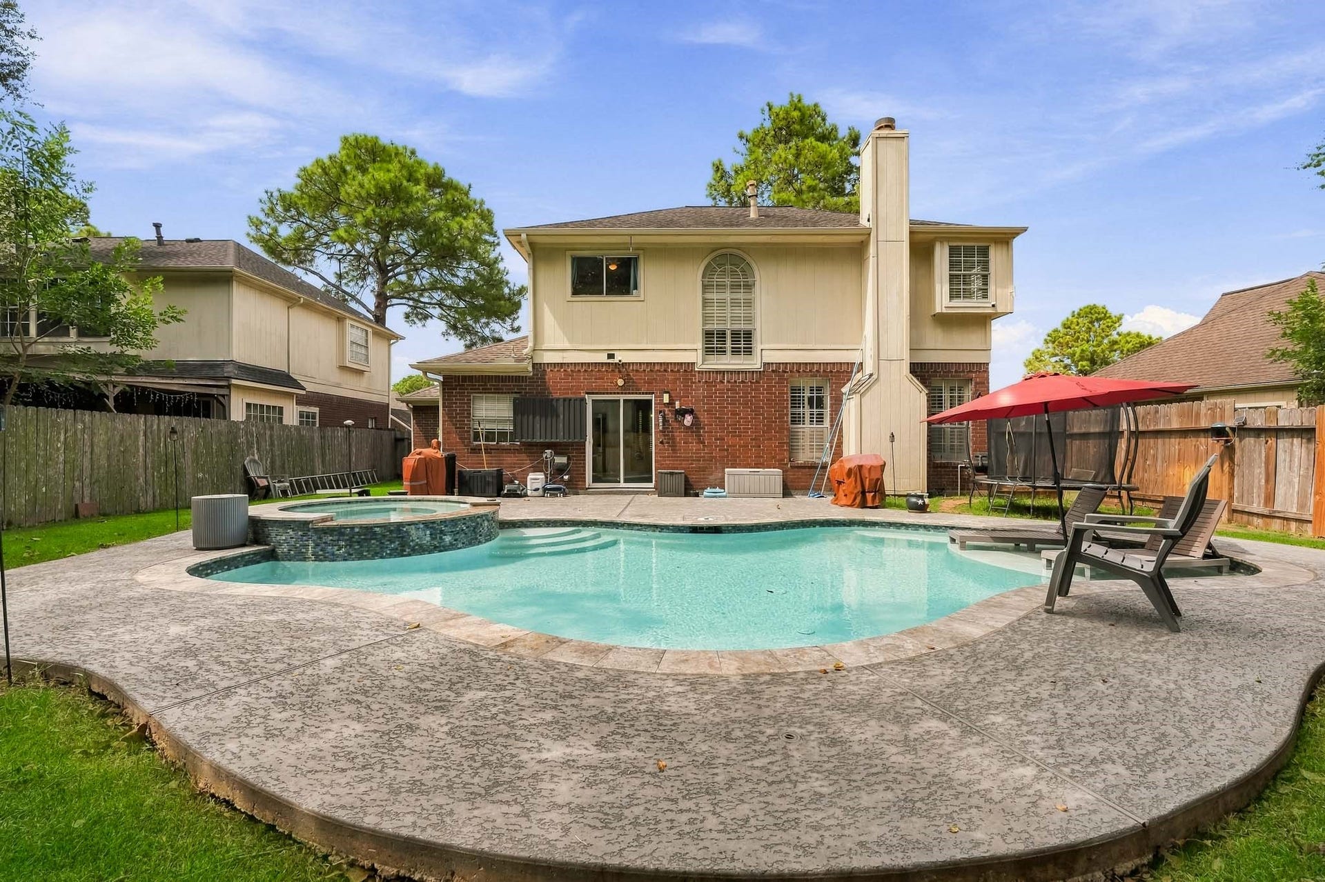 4811 Red Lantern Drive, Friendswood, TX 77546 Charming two-story home with a spacious backyard, featuring a beautifully designed pool and spa, perfect for outdoor entertaining and relaxation.