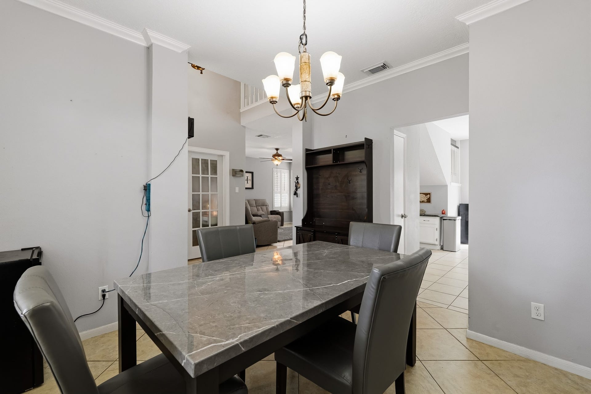 4811 Red Lantern Drive, Friendswood, TX 77546 Elegant dining area with a stylish chandelier, seamlessly connected to the living space through the entry hallway.