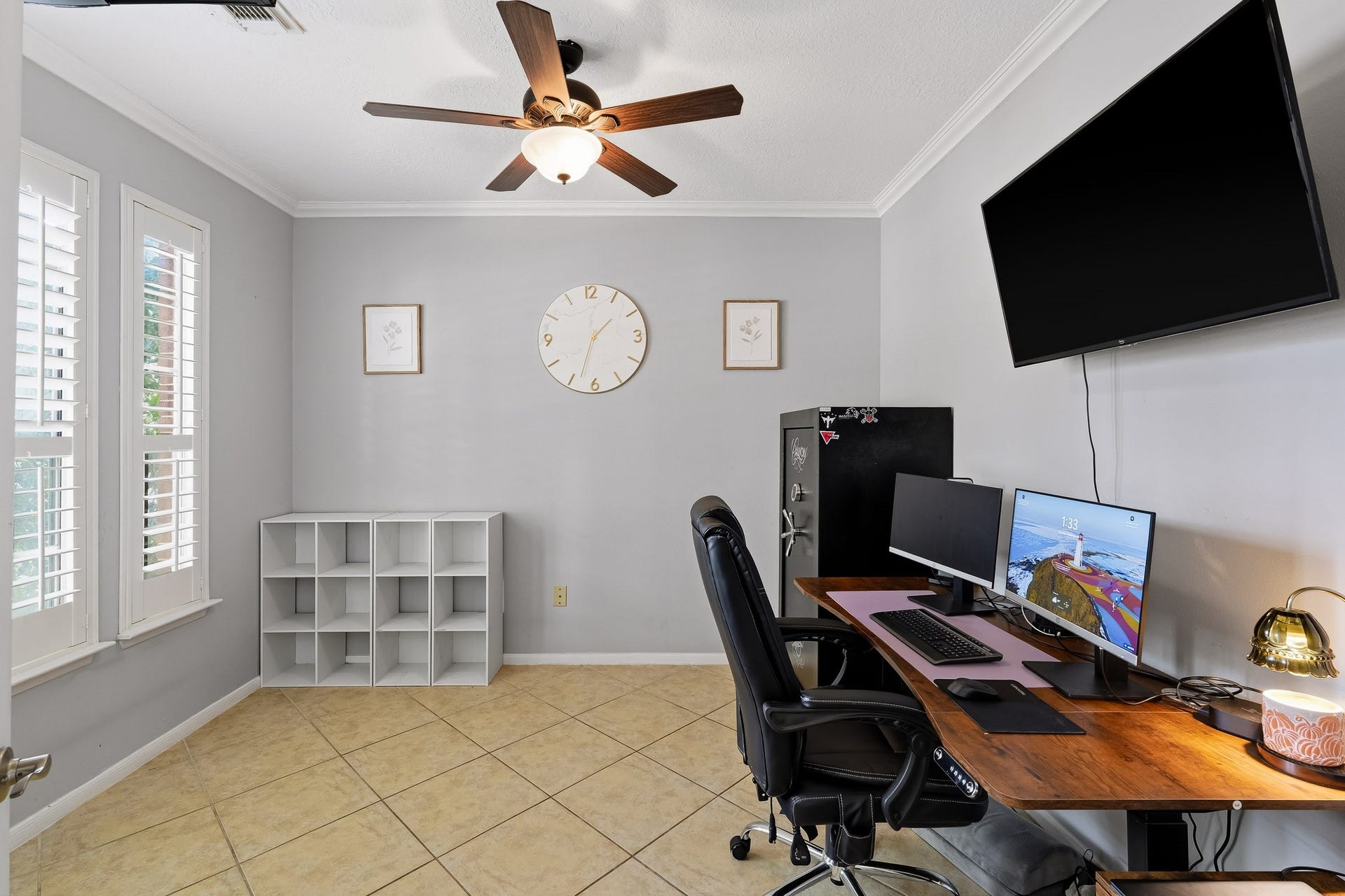 4811 Red Lantern Drive, Friendswood, TX 77546 Bright and functional home office featuring a ceiling fan and ample natural light from plantation shutters, creating an ideal workspace.