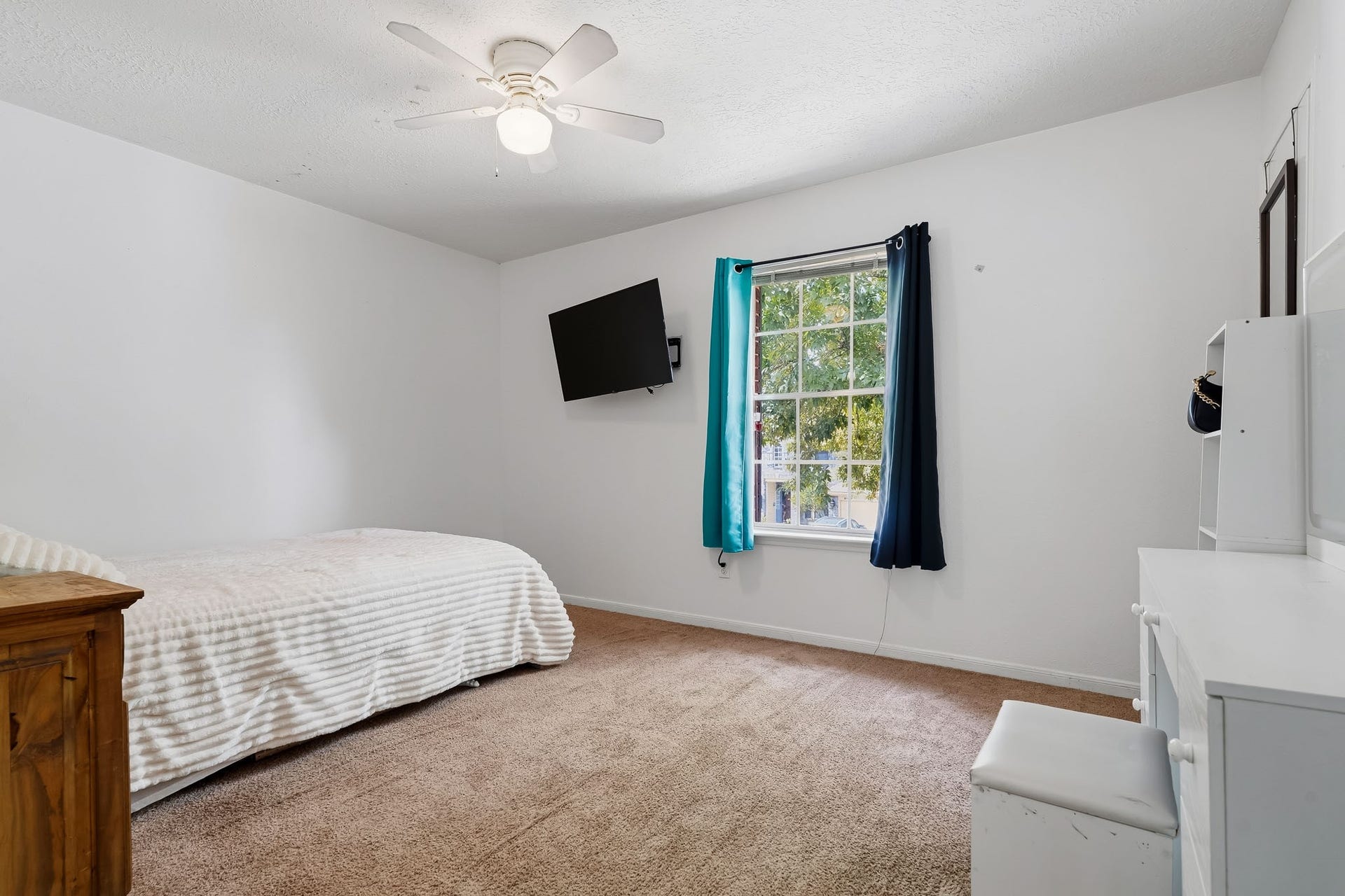 4811 Red Lantern Drive, Friendswood, TX 77546 Bright and cozy bedroom featuring a window, plush carpeting, and a ceiling fan for comfort.