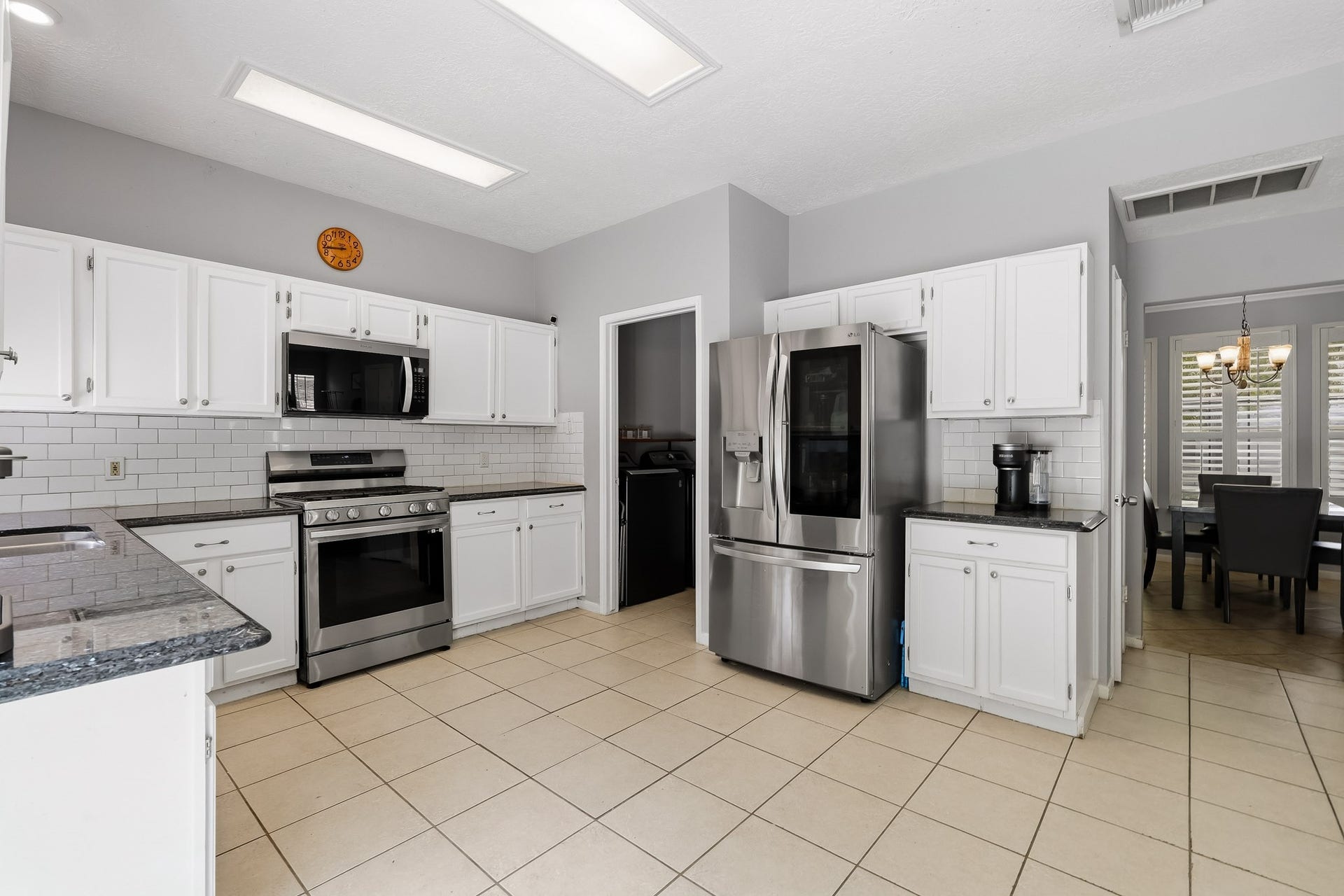 4811 Red Lantern Drive, Friendswood, TX 77546 Bright, spacious kitchen featuring sleek stainless steel appliances, crisp white cabinetry, and elegant subway tile backsplash.