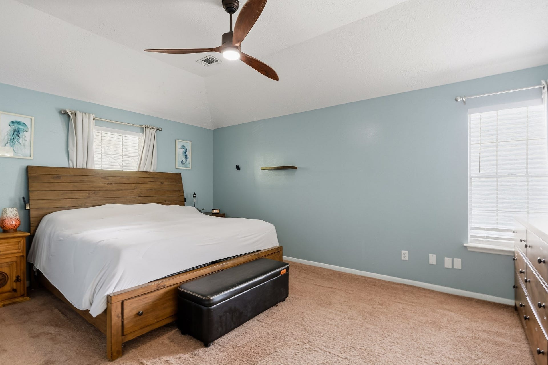4811 Red Lantern Drive, Friendswood, TX 77546 Spacious bedroom with a vaulted ceiling, featuring soft carpeting and ample natural light from dual windows.