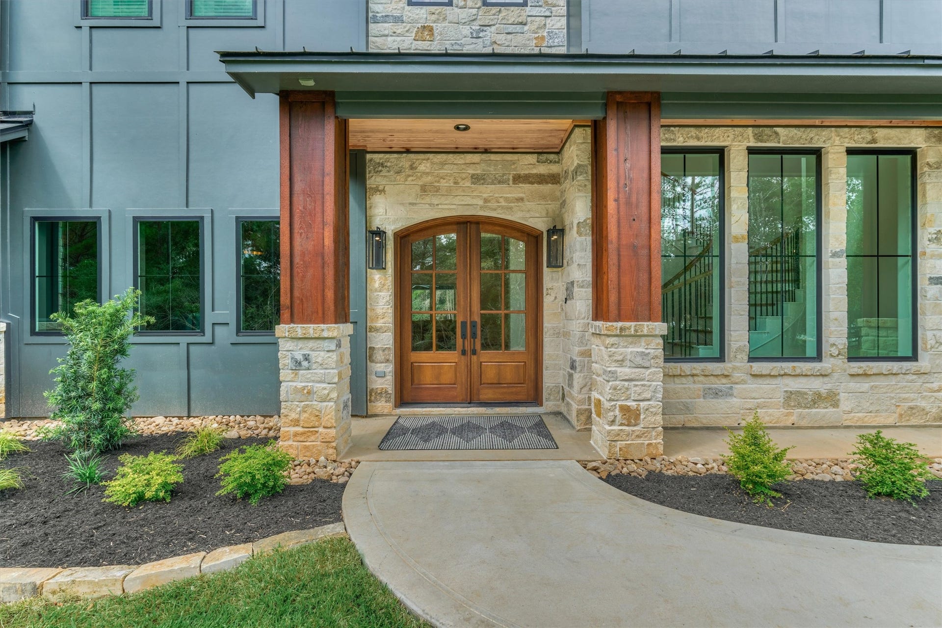 8616 Grand Lake Estates Drive, Montgomery, TX 77316 Charming covered front porch with exterior stone accents and glass-paneled double doors opening to the breathtaking interior.