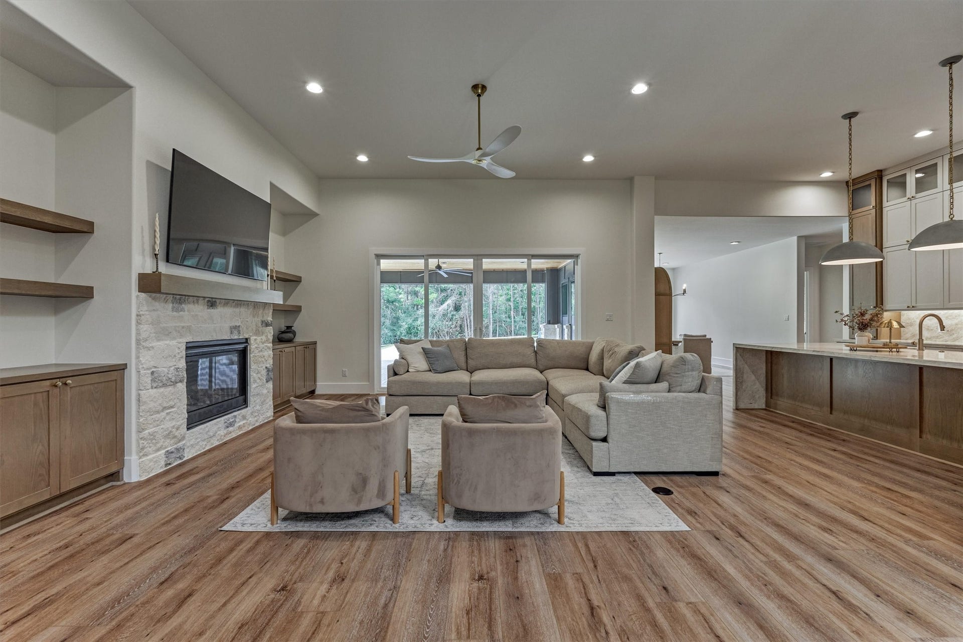 8616 Grand Lake Estates Drive, Montgomery, TX 77316 Expansive den features a wall of custom built-ins and a fireplace with stone surround, opening seamlessly to the exceptional chefs kitchen.