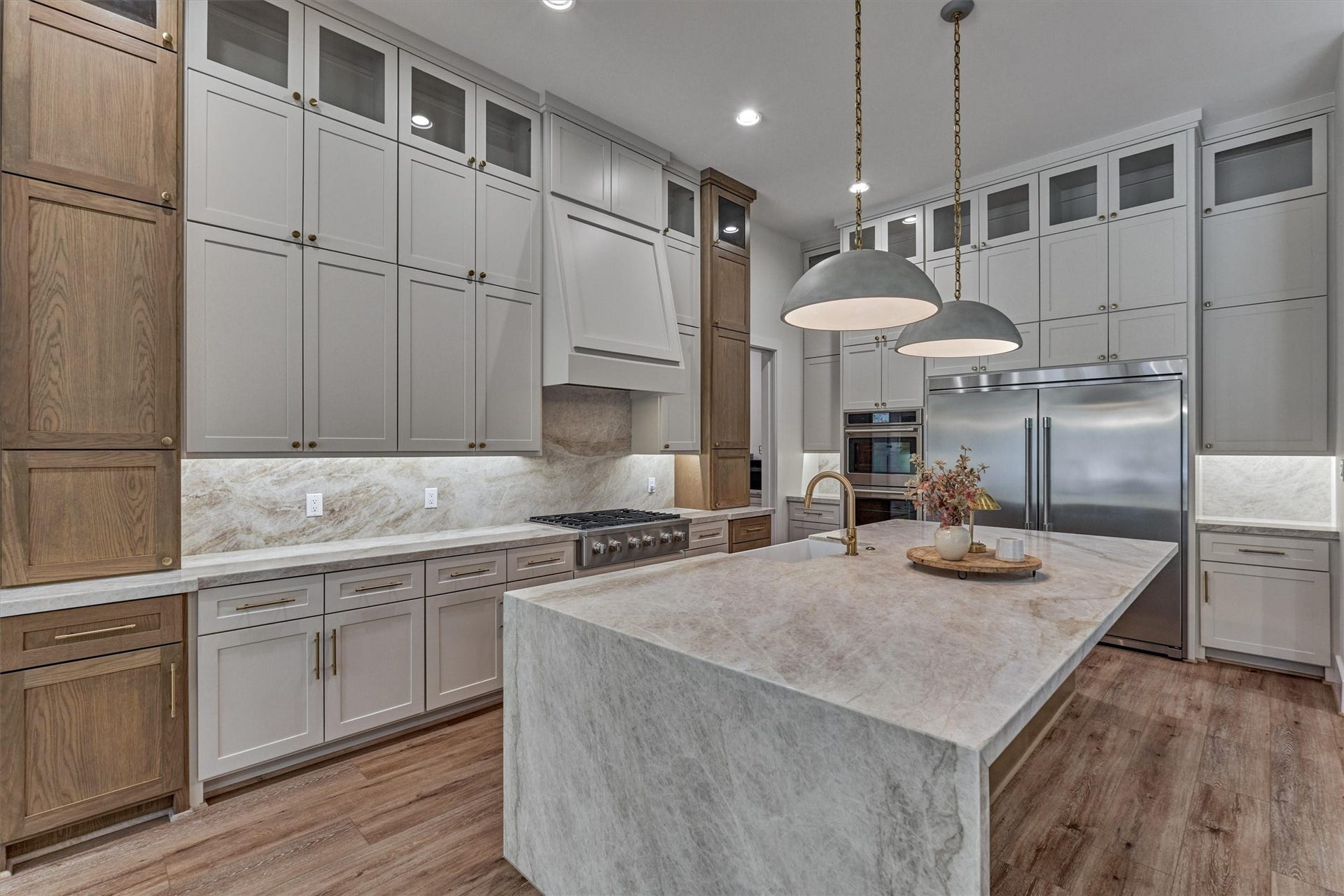 8616 Grand Lake Estates Drive, Montgomery, TX 77316 Take note of the striking pendant lighting over the waterfall countertop island for dramatic effect! Wrapped quartzite from countertops to backsplash is another upgraded feature for a polished look! And stained cabinets are back for soothing elegance!